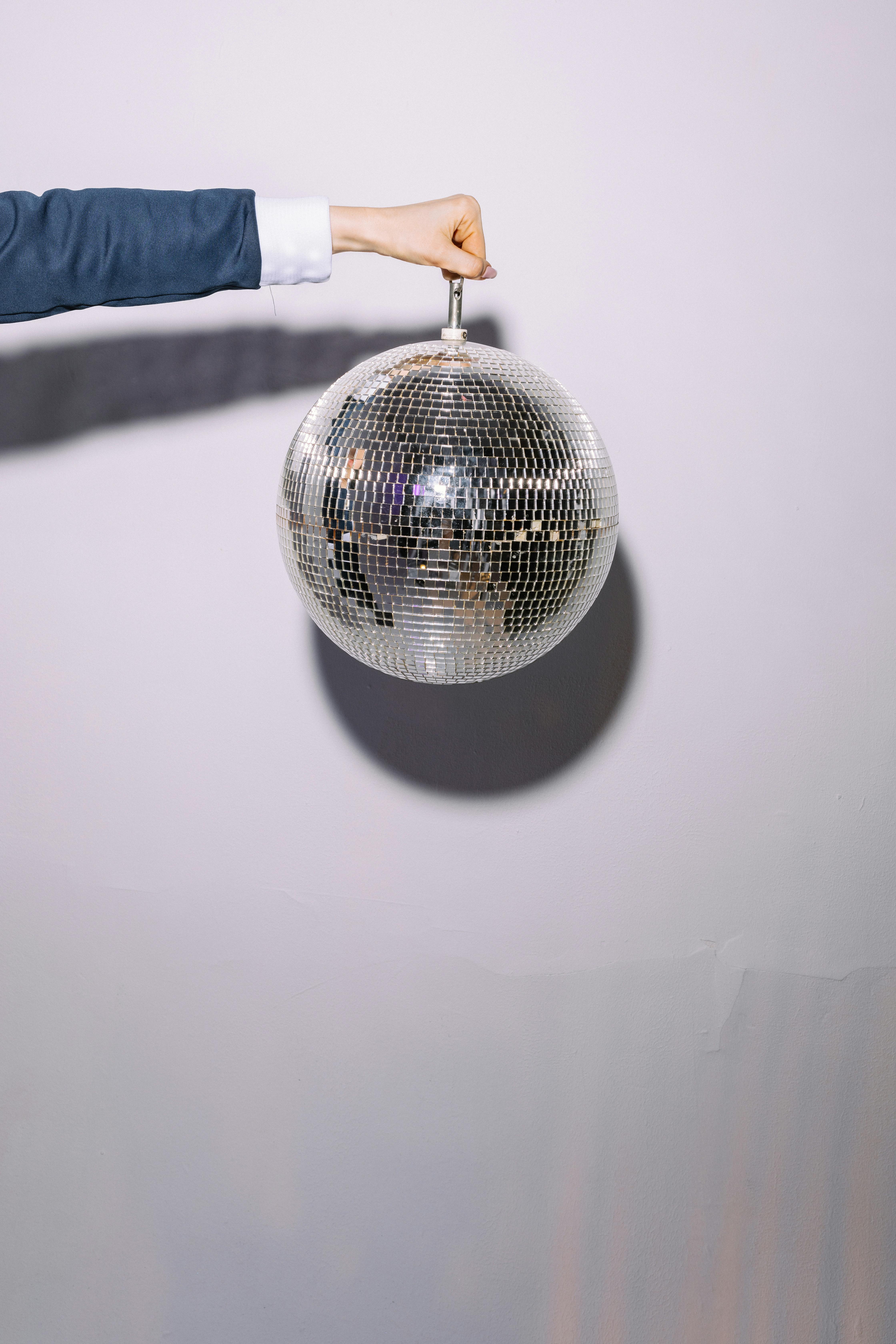 Photo of a Person's Hand Carrying a Disco Ball