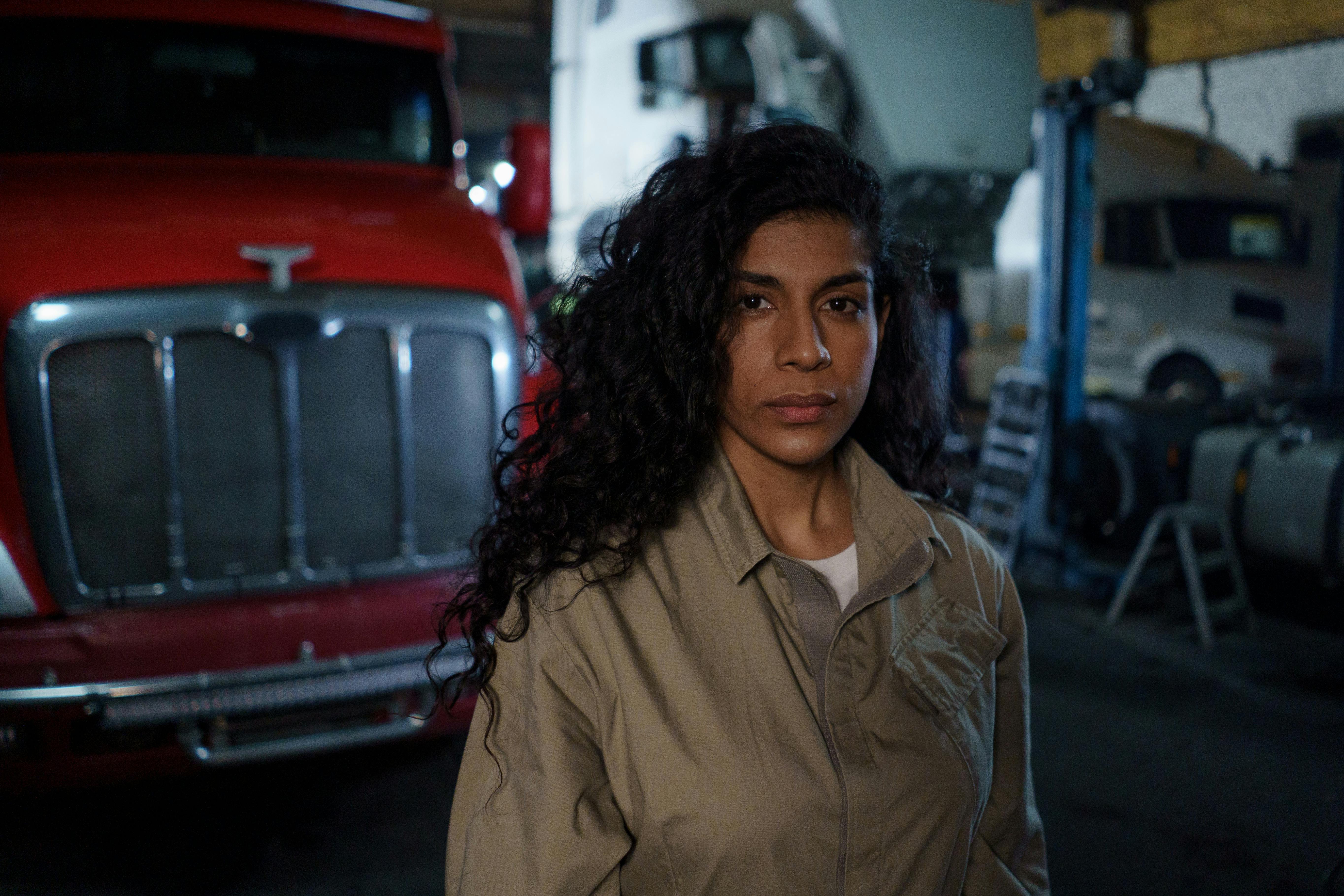 Woman In Brown Uniform Standing In A Garage