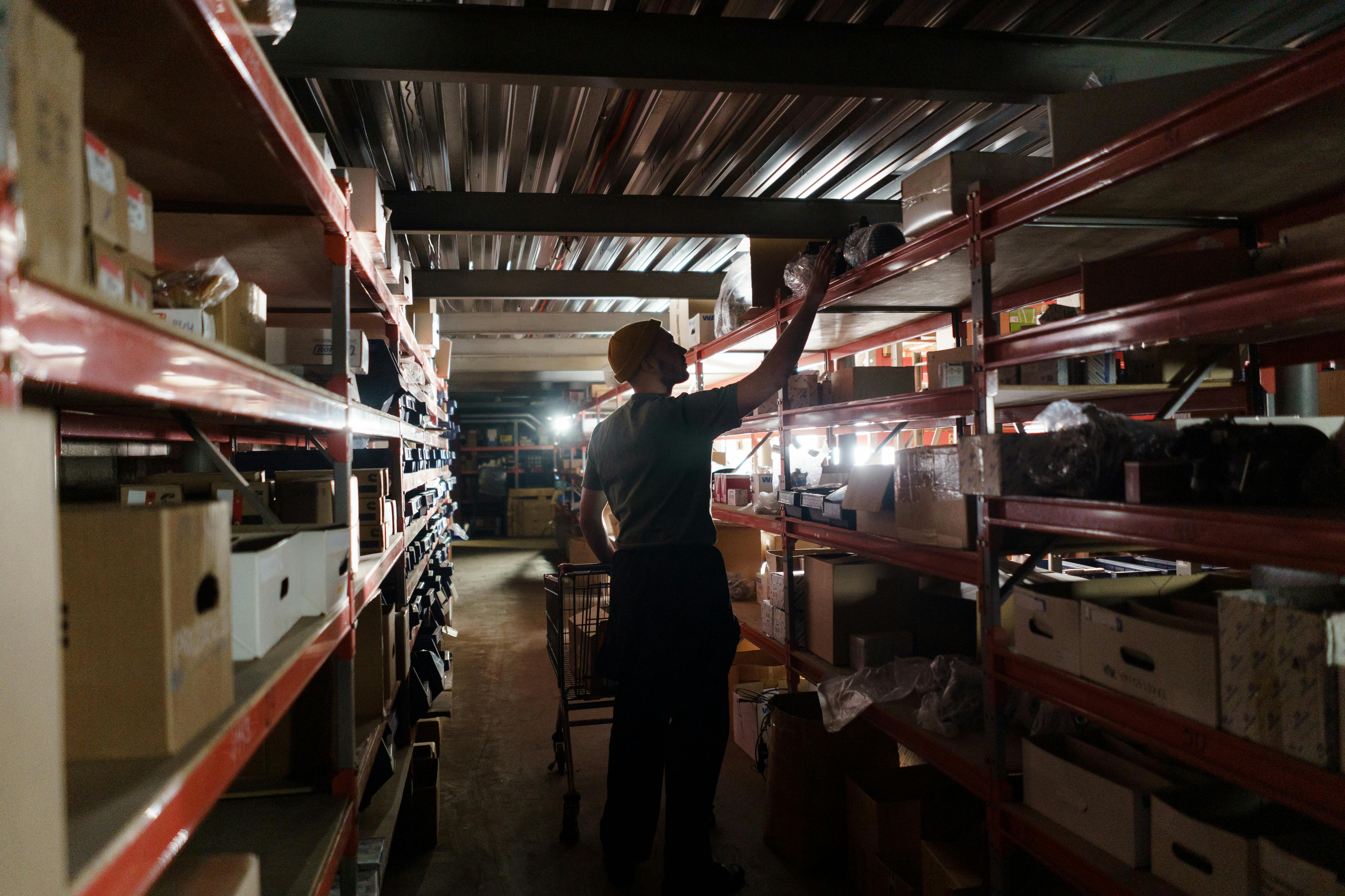 Photo of a Man Arranging in a Depot