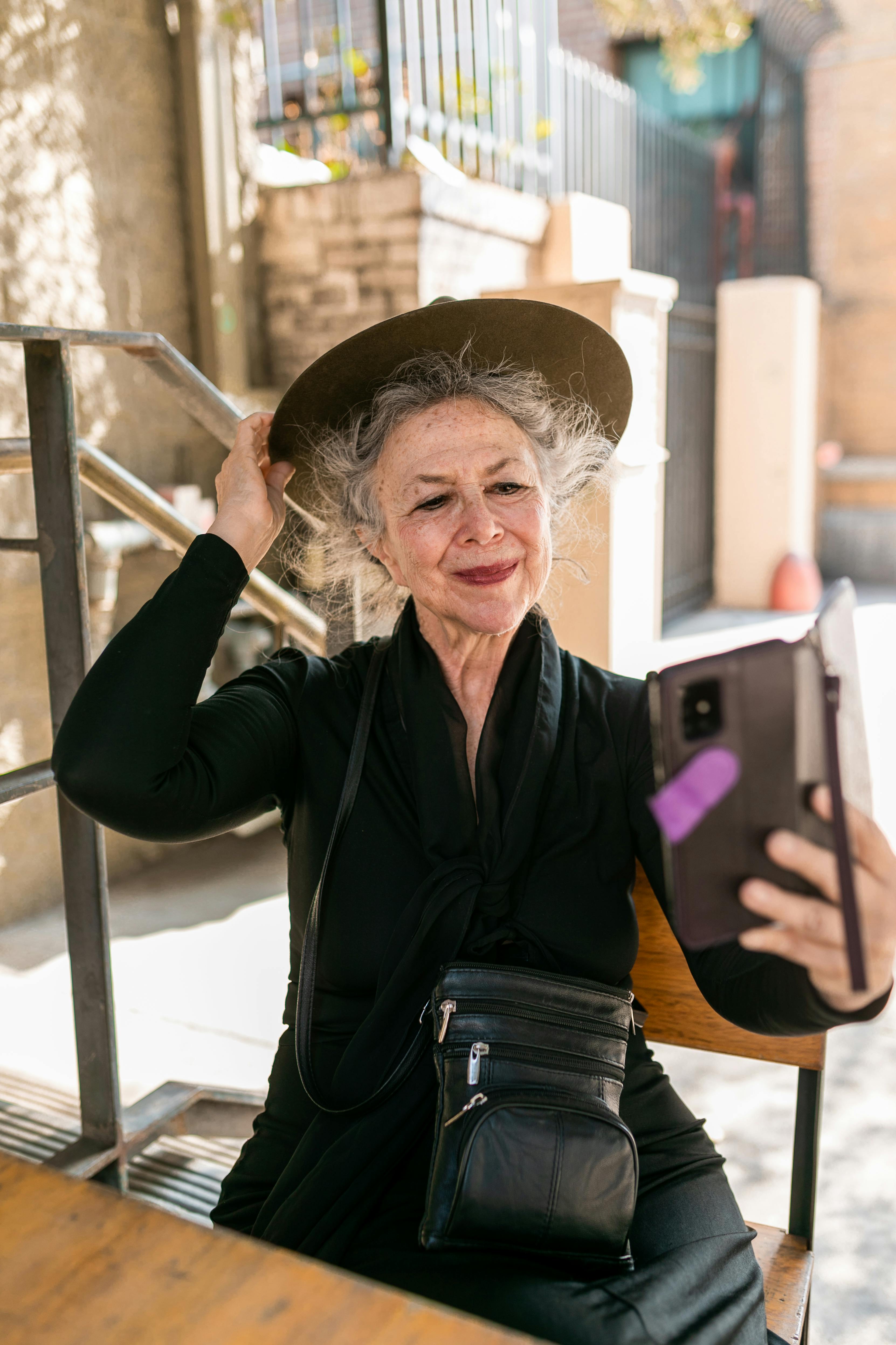 Woman in Black Long Sleeve Dress Holding Smartphone