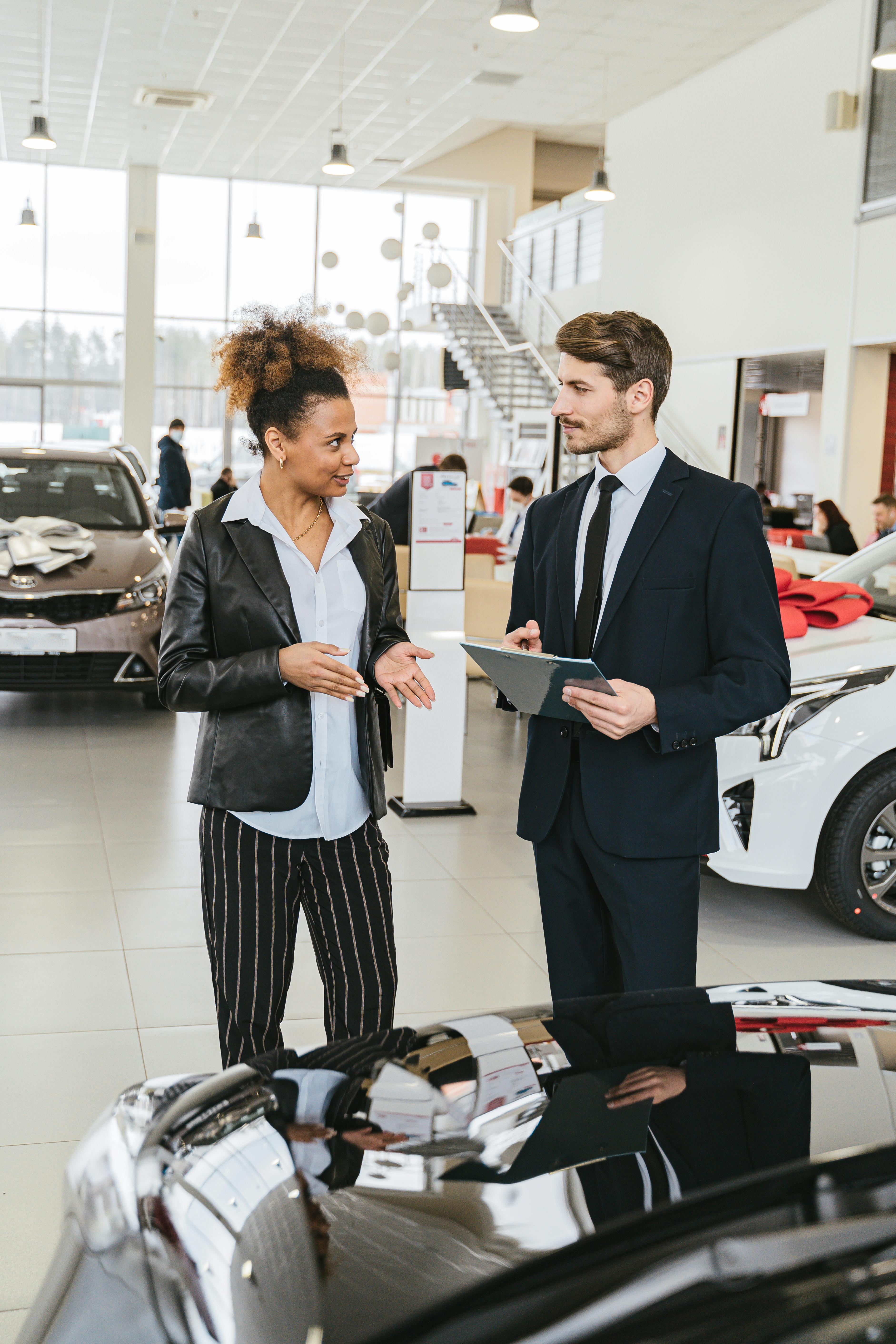 Man in Business Suit Discussing with Woman in Black Blazer