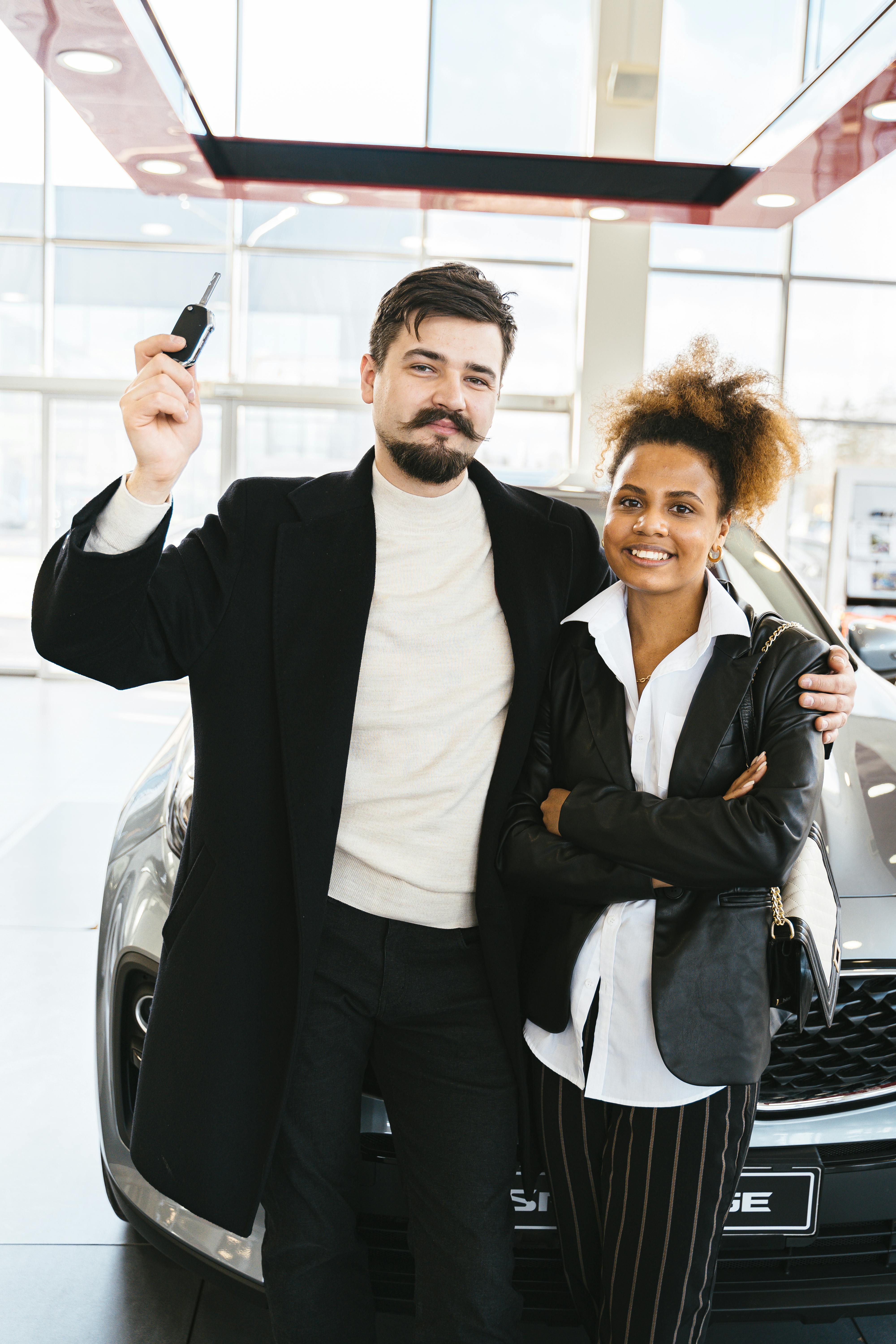 A Couple Standing in Front of a Brand New Car