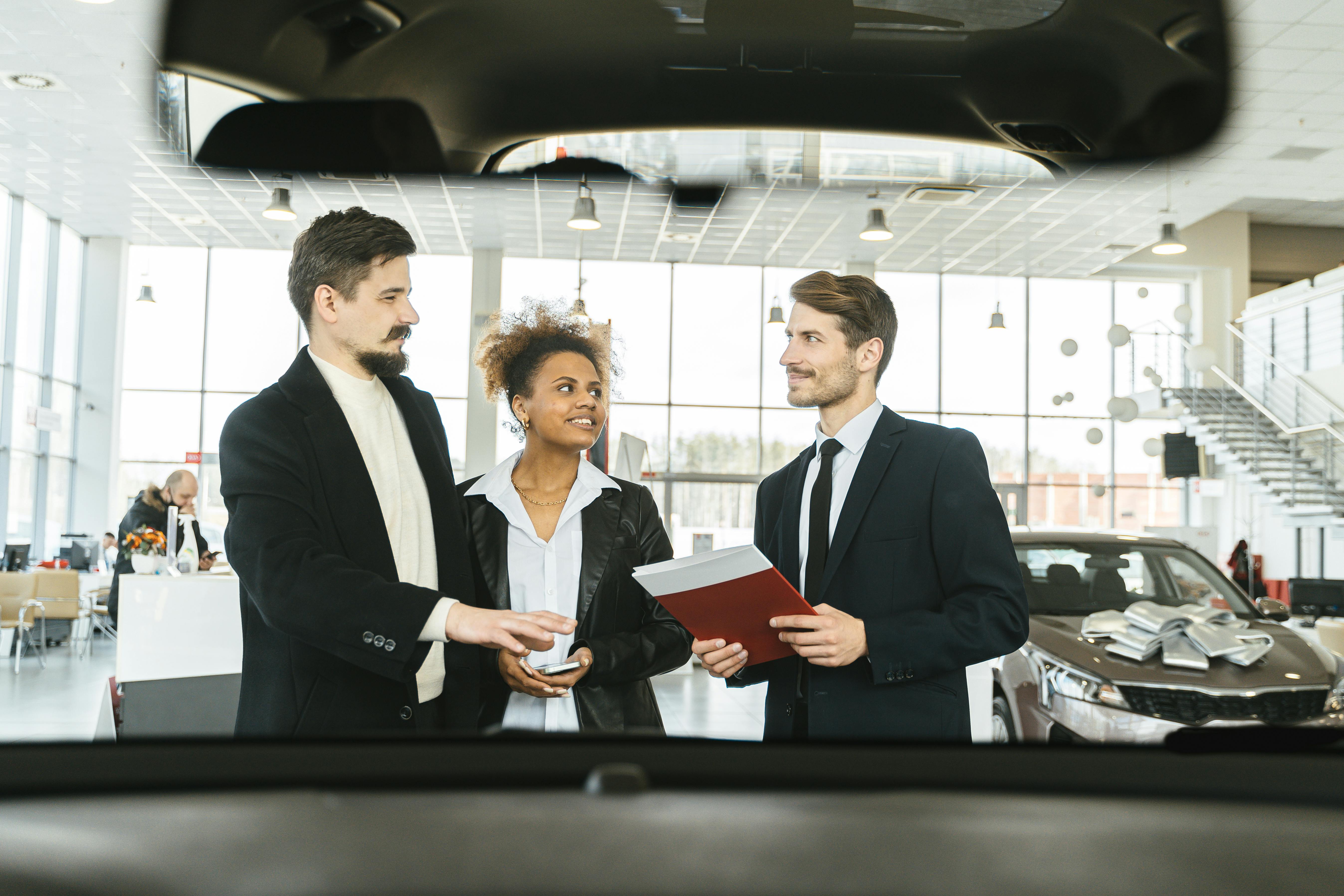 A couple engaging with a car rental salesman