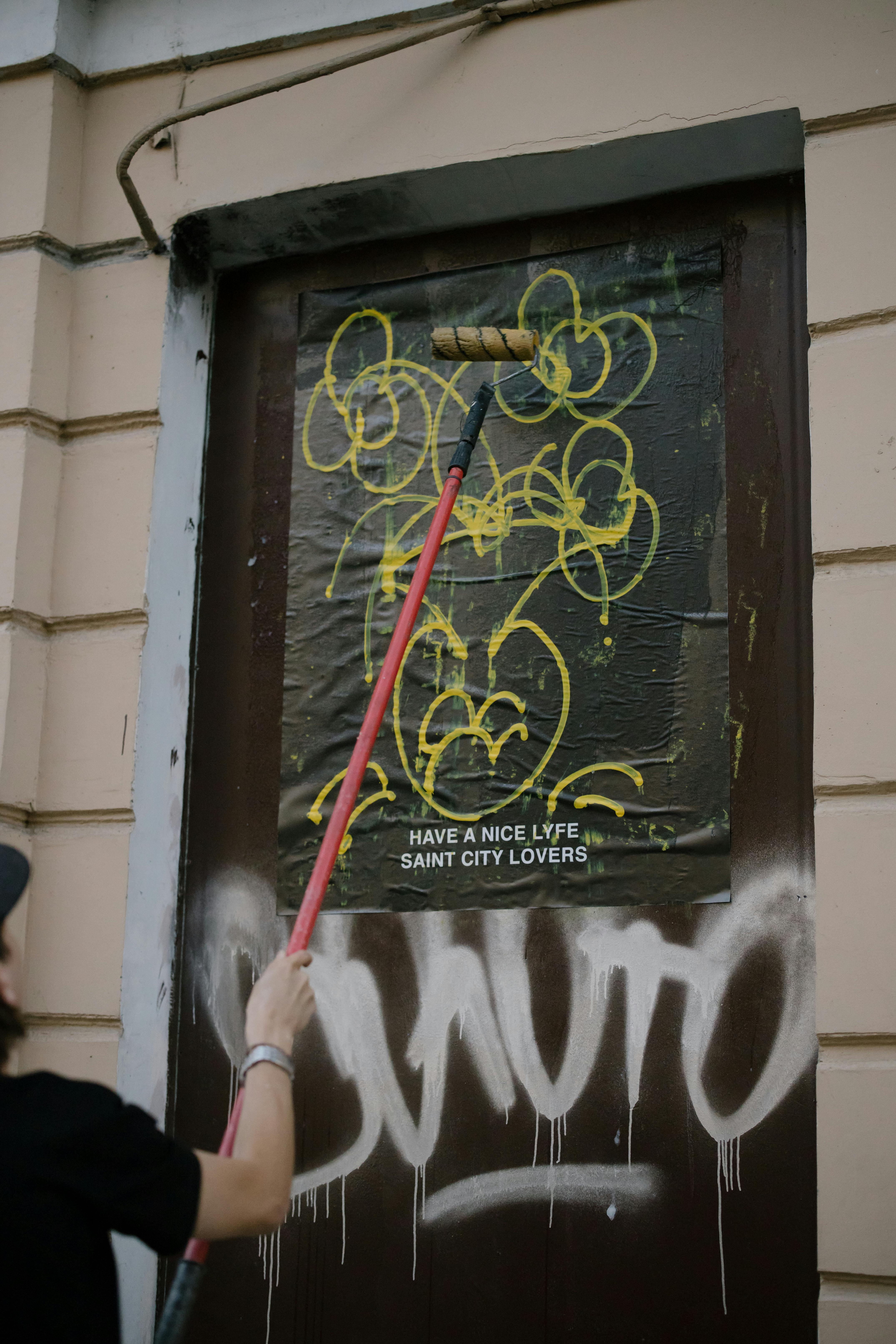 Person Cleaning a Vandalized Wooden Door