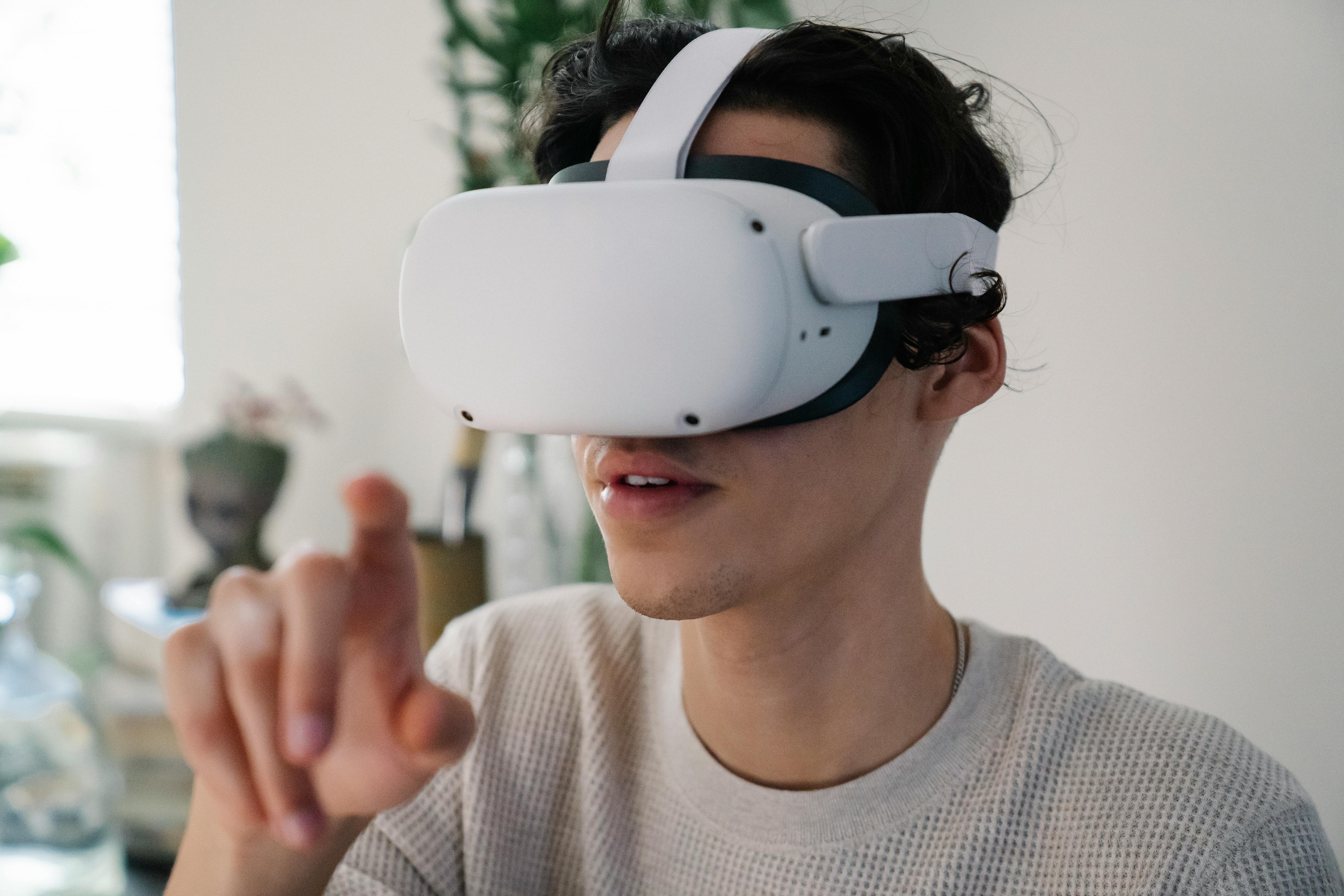 Young male interacting with virtual reality headset in apartment