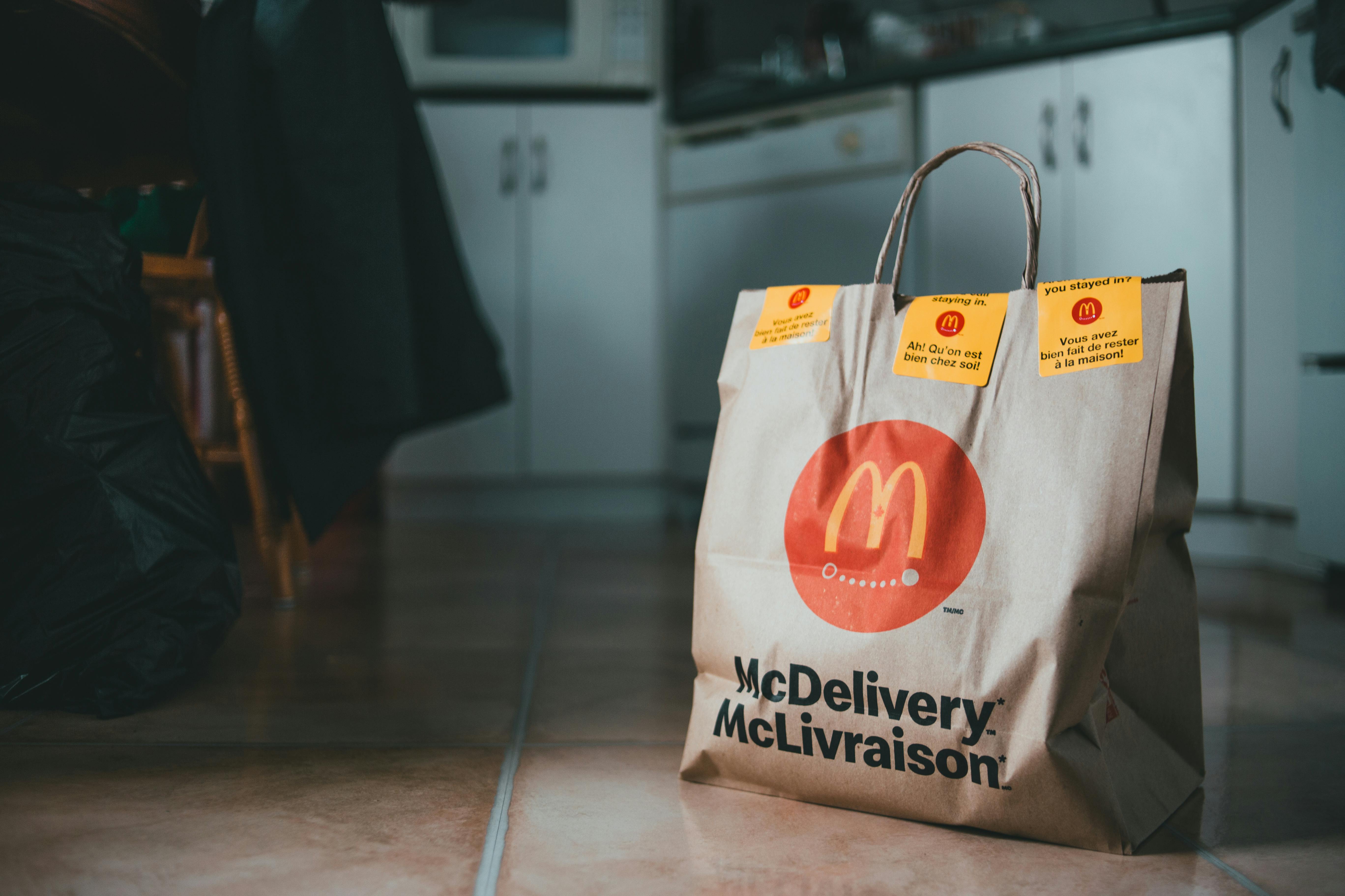 Organic delivery bag with tasty fast food on ceramic floor