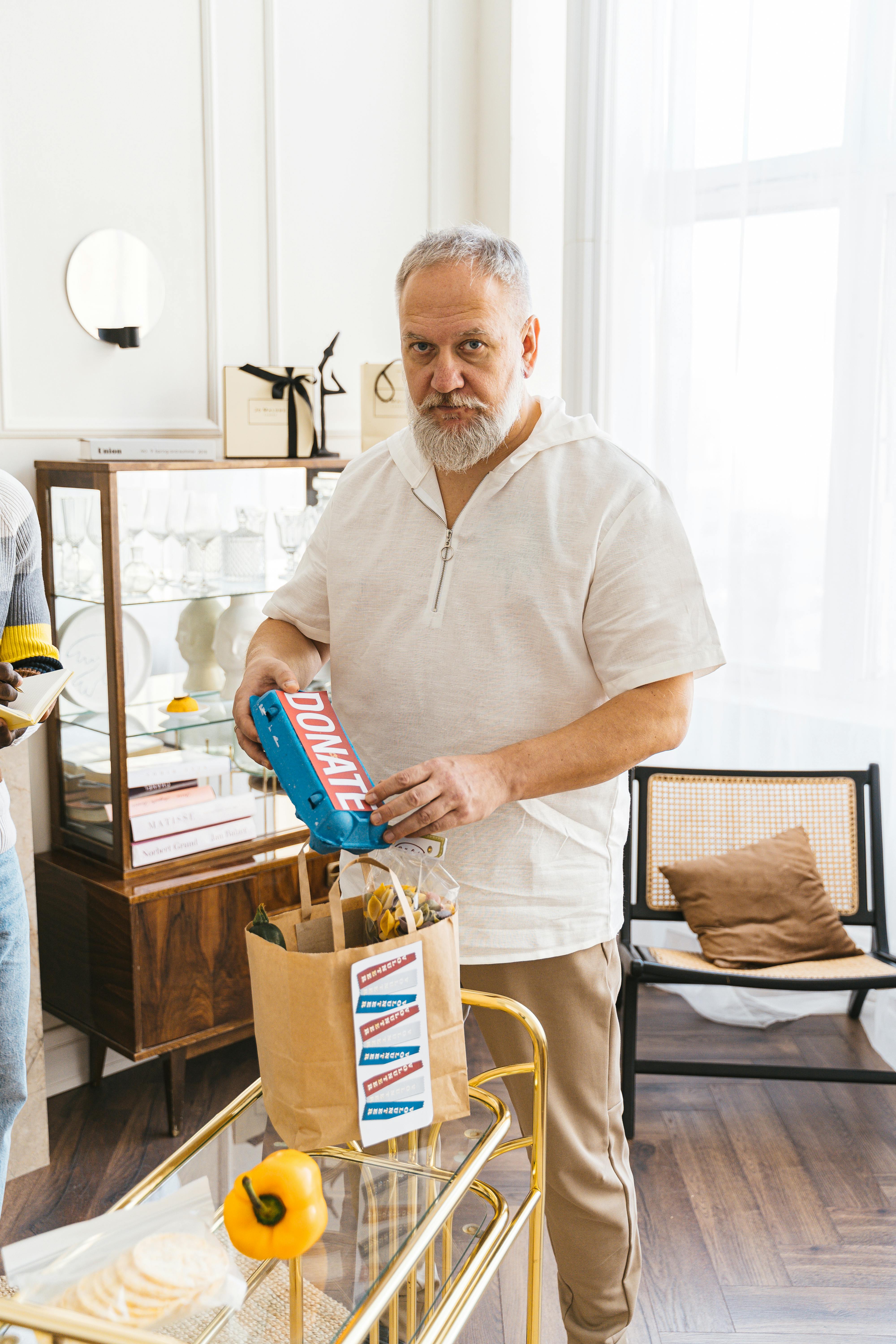 A Man in White Shirt Holding a Carton of Eggs 