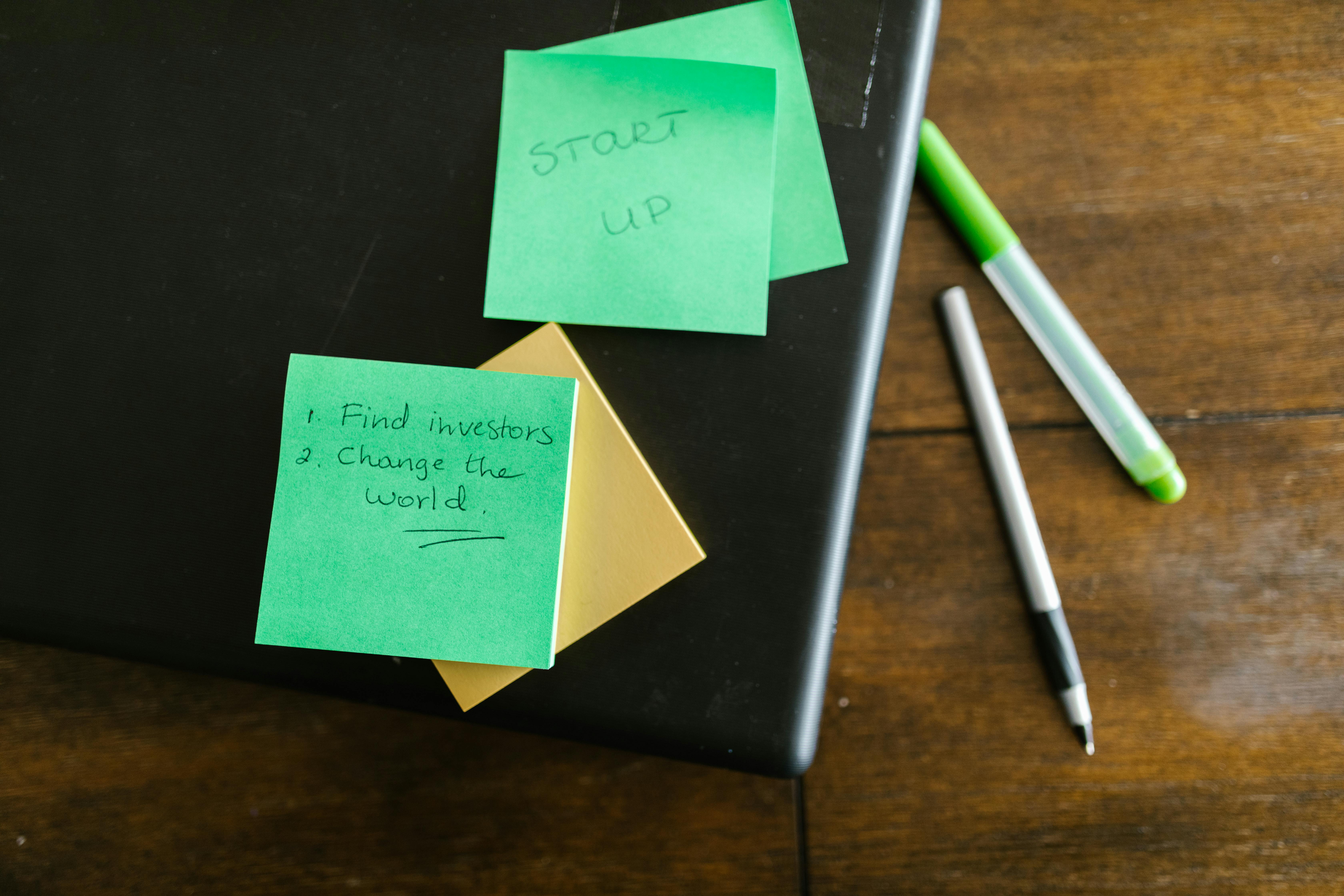 Green Sticky Note Beside White and Green Pen