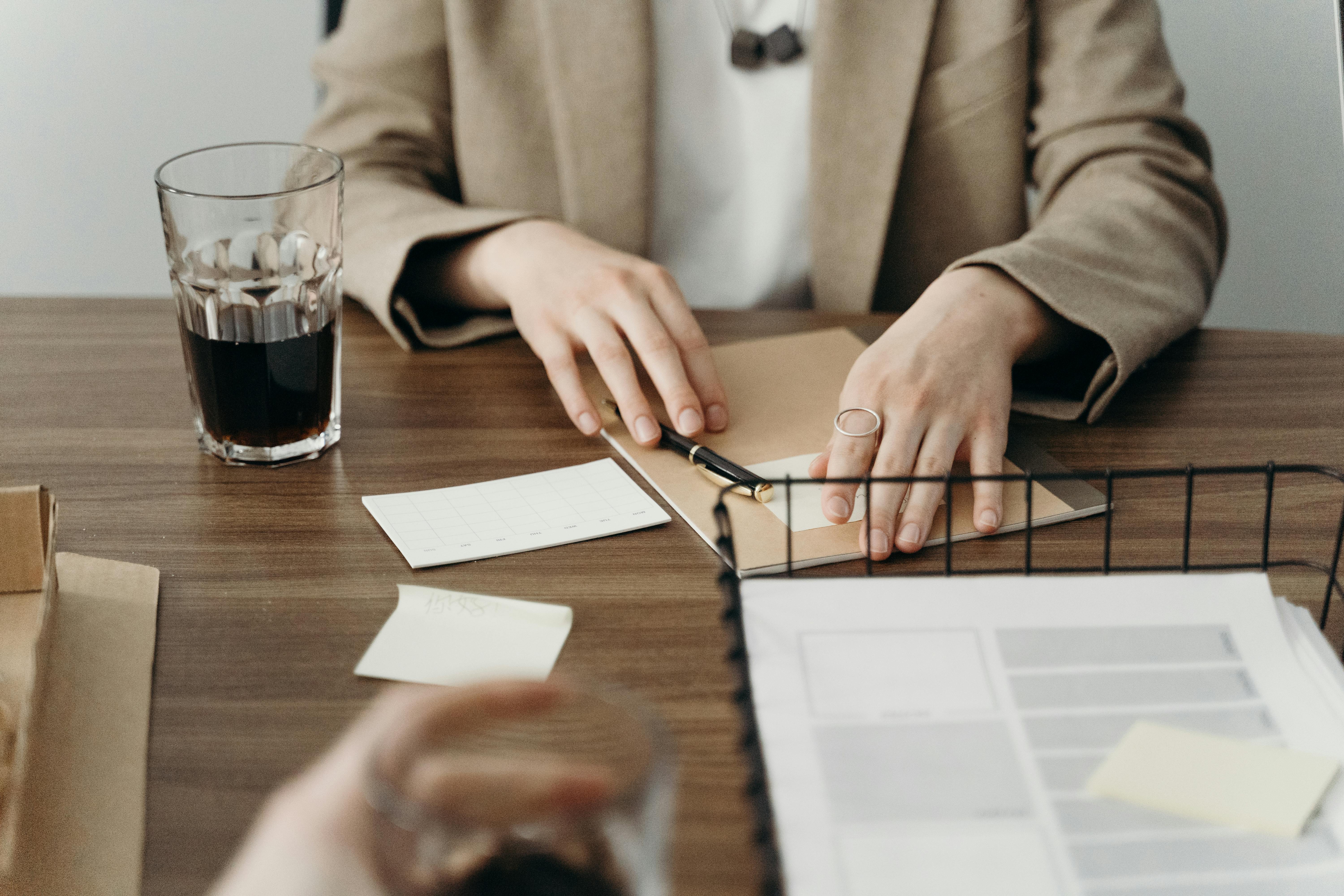 Person Holding a Pen and Paper