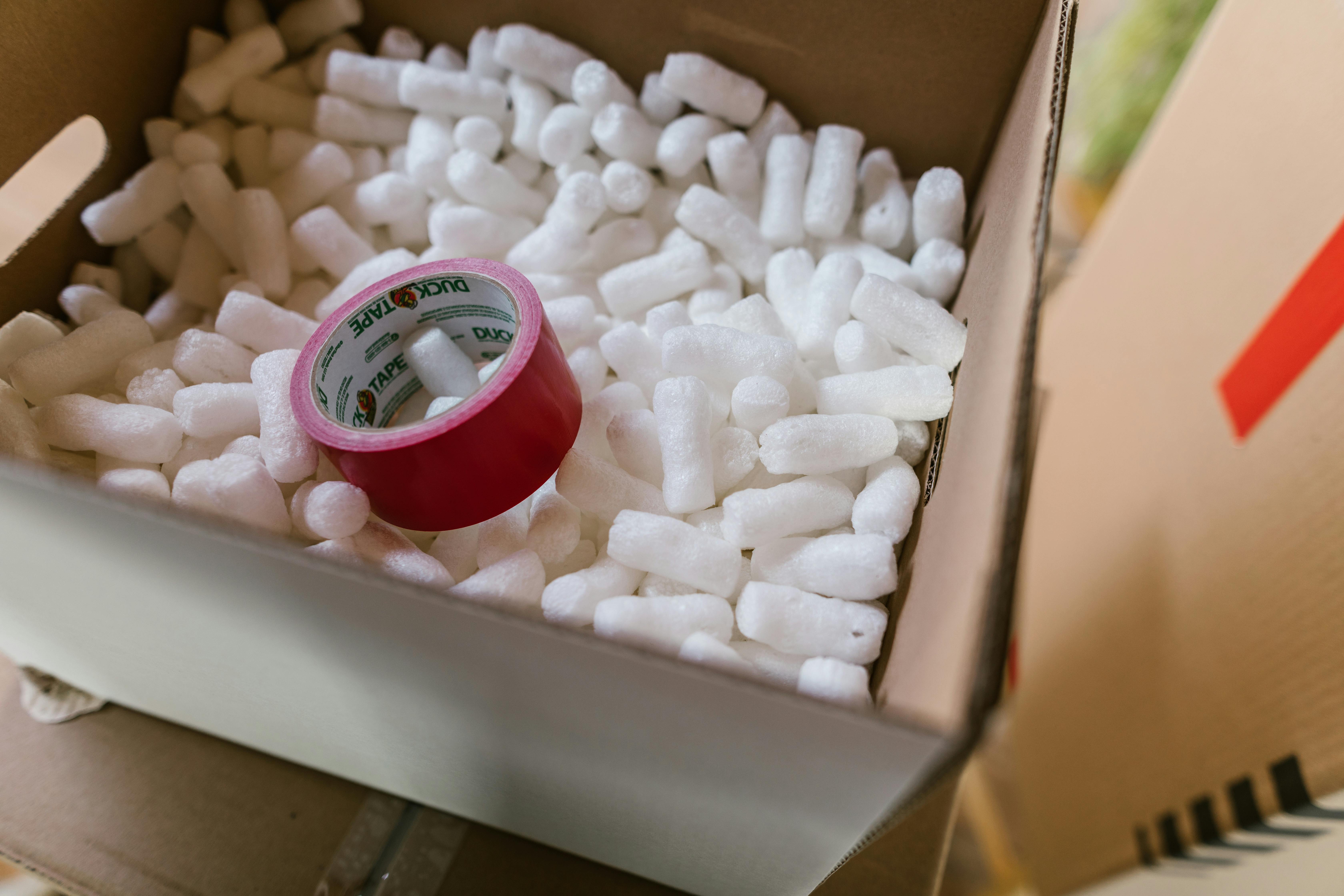 Photo showcasing red tape and polystyrene packaging, symbolizing logistics efficiency.