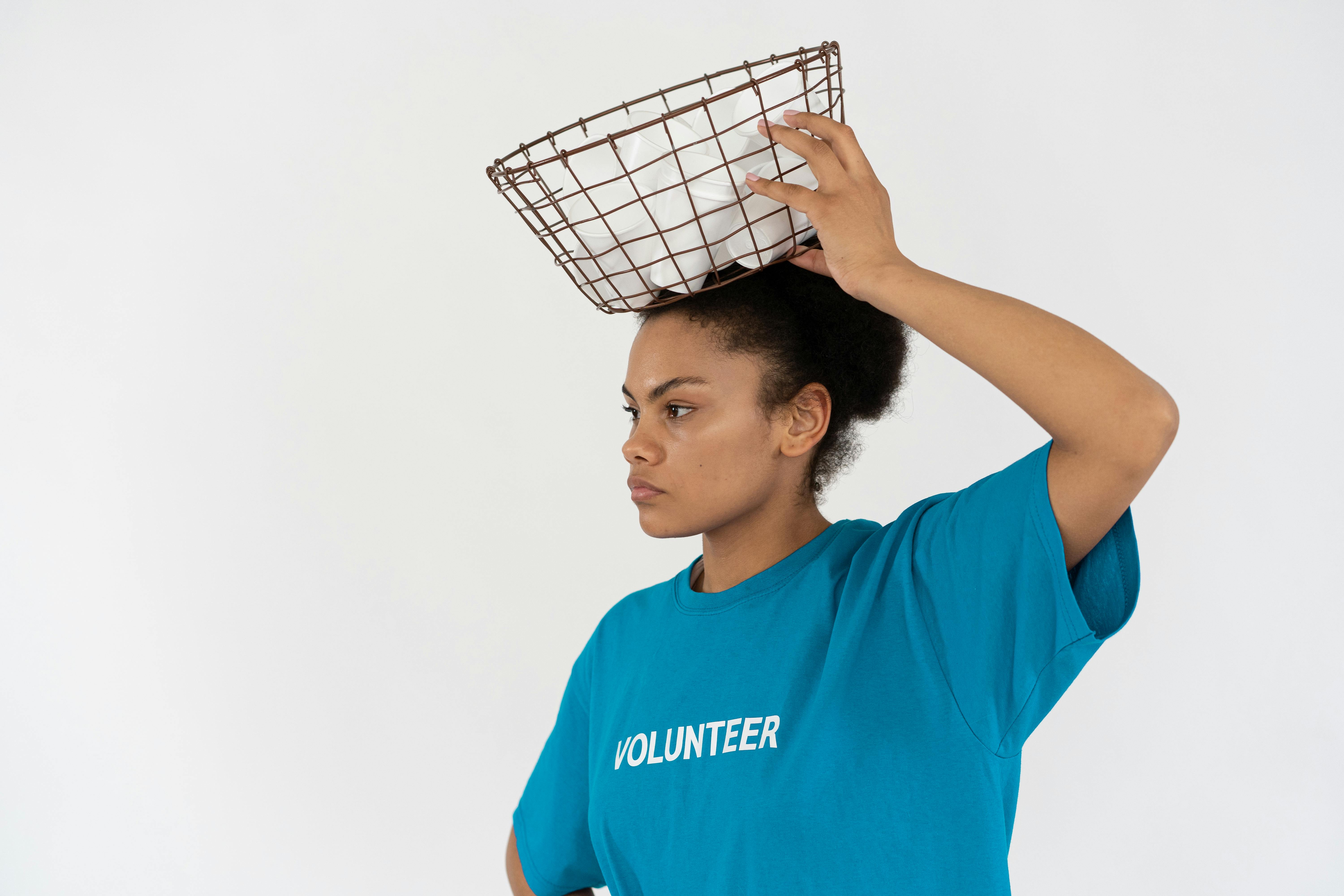 A Woman Wearing a Blue Shirt Carrying a Metal Basket
