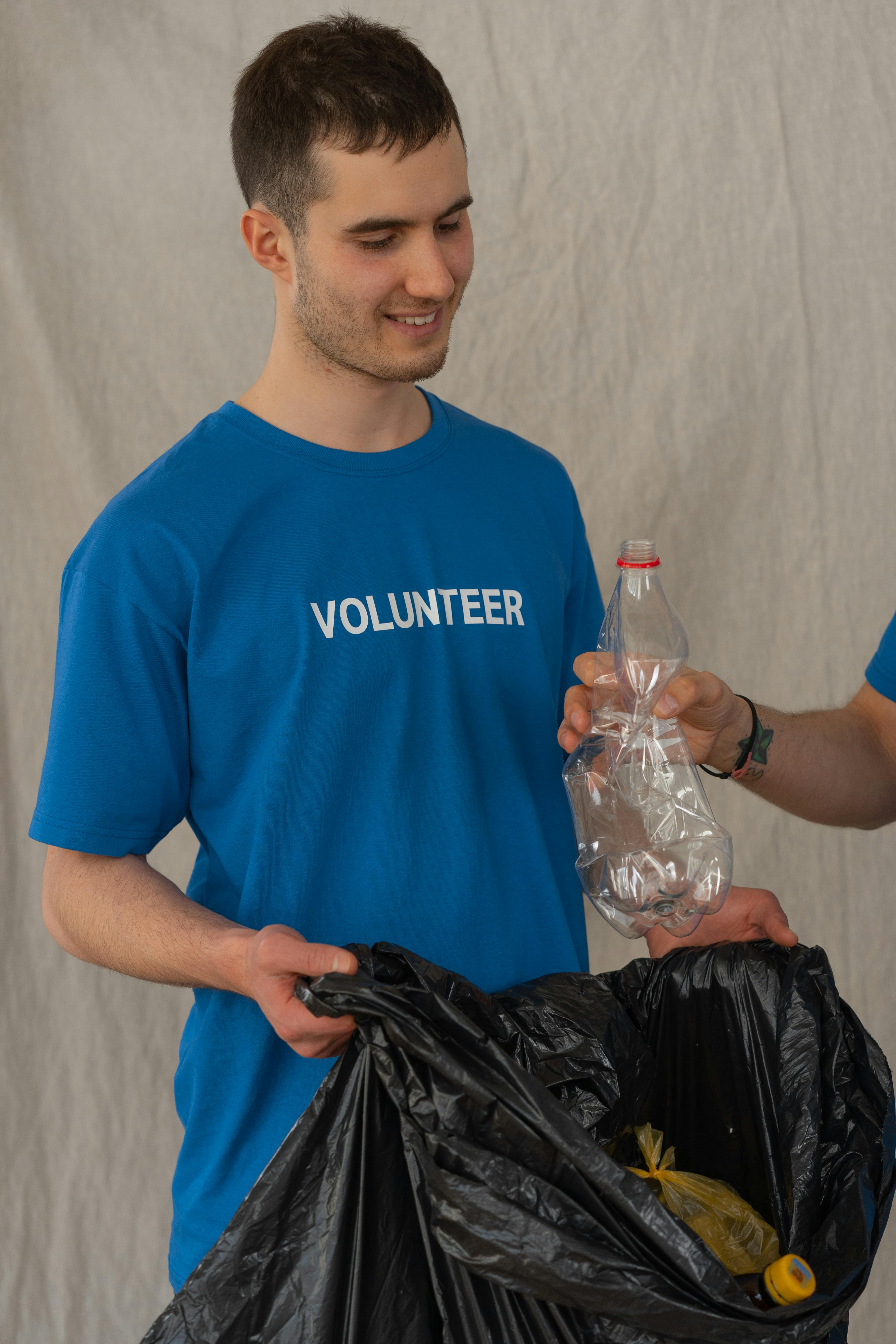 Man in Blue Crew Neck T-shirt Holding Clear Plastic Bottle