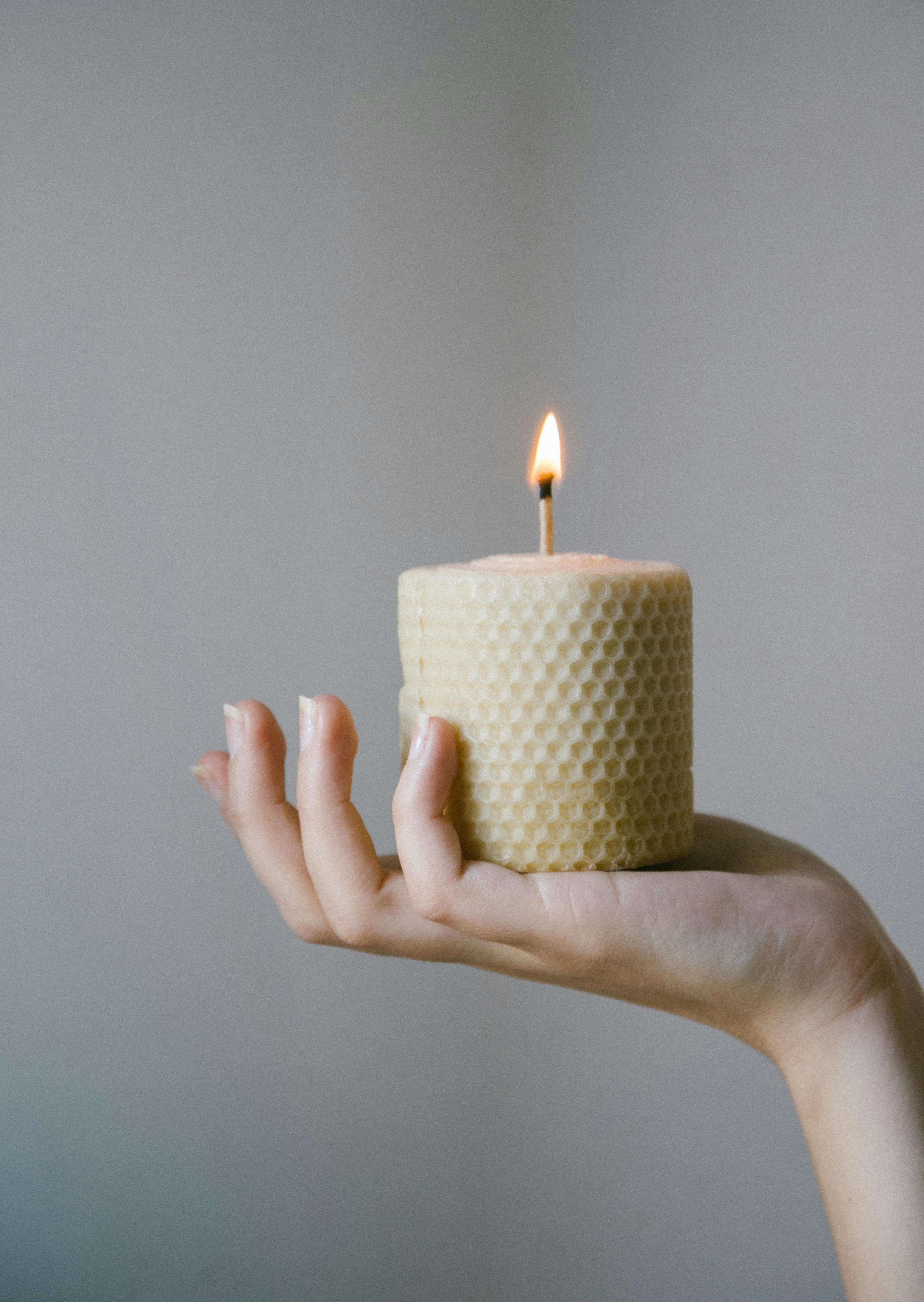 Photo of a Person's Hand Holding an Eco-Friendly Candle