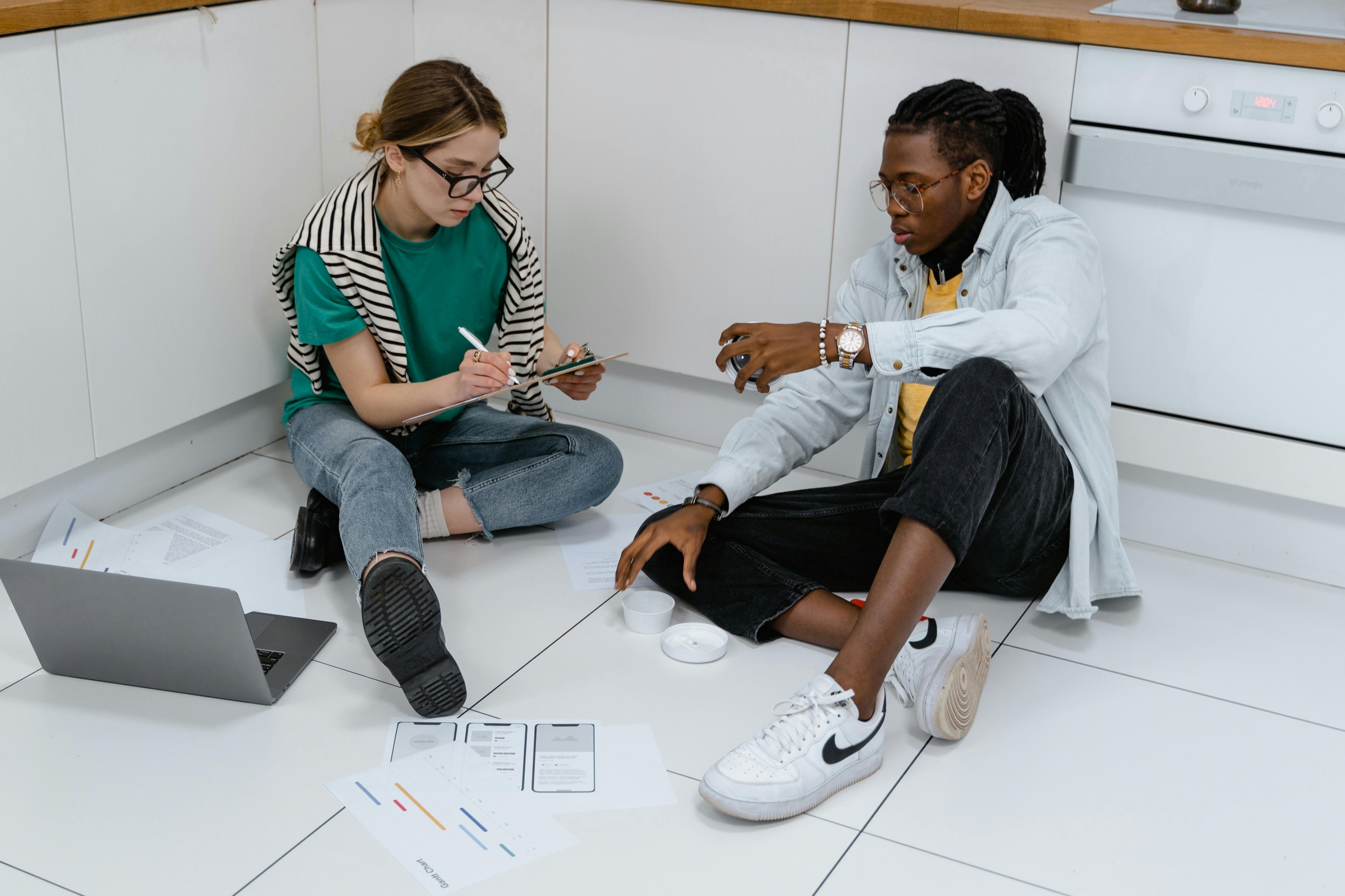 A Man and a Woman Working while Sitting on the Floor