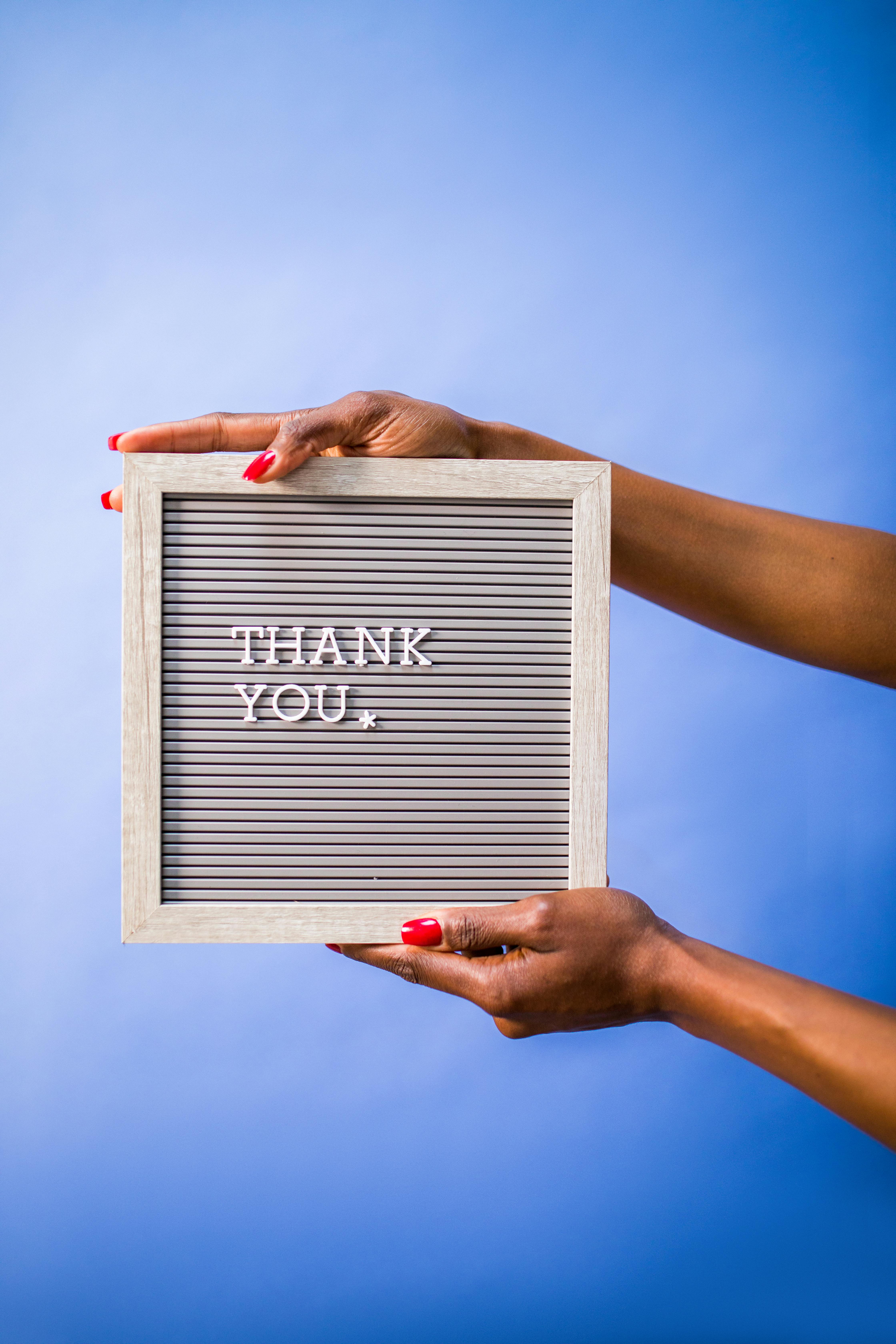 Person Holding a Board with a Text Saying 