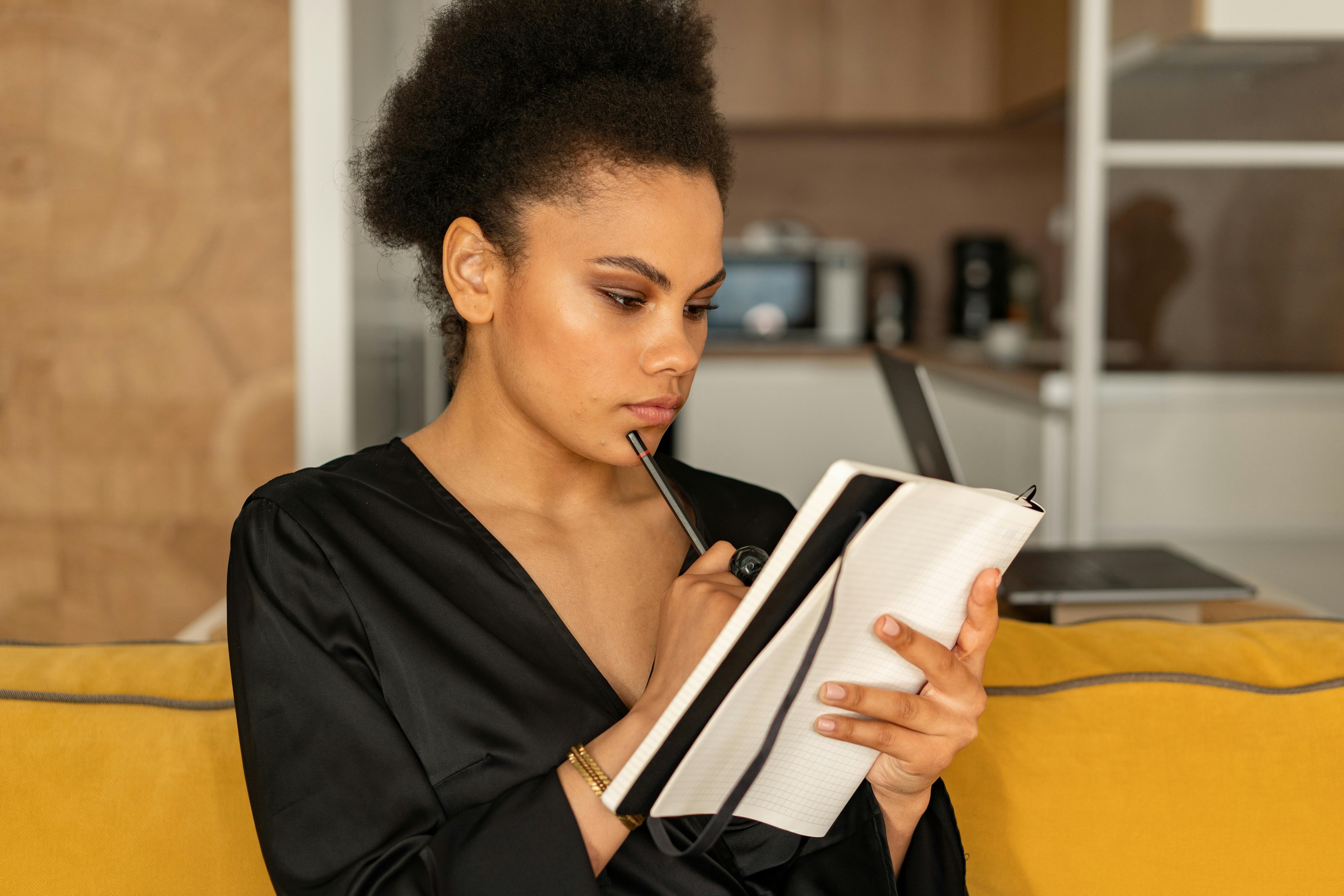 A Woman in Black Blouse Holding a Notebook