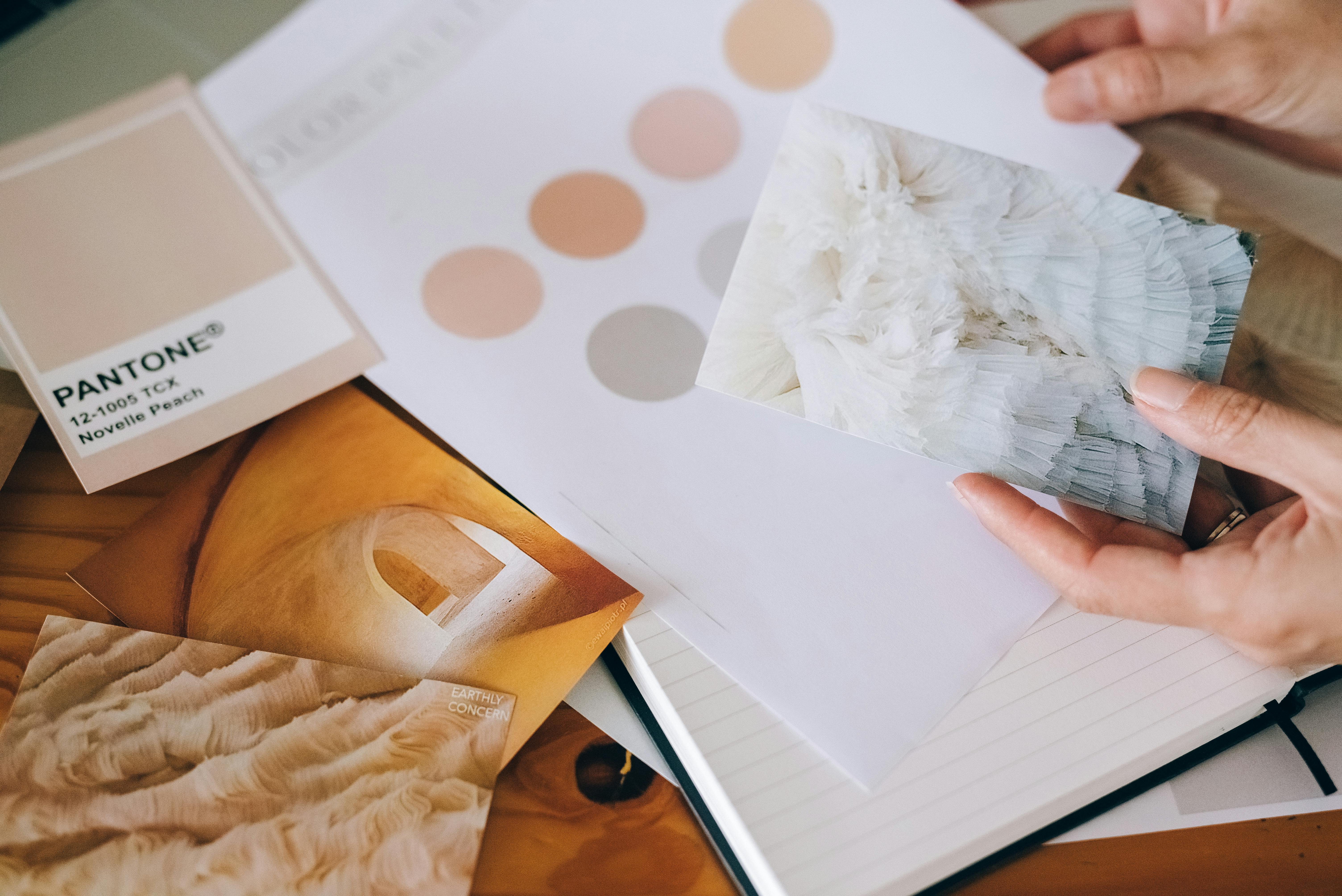 Hands Holding Card over Paper and Notebook