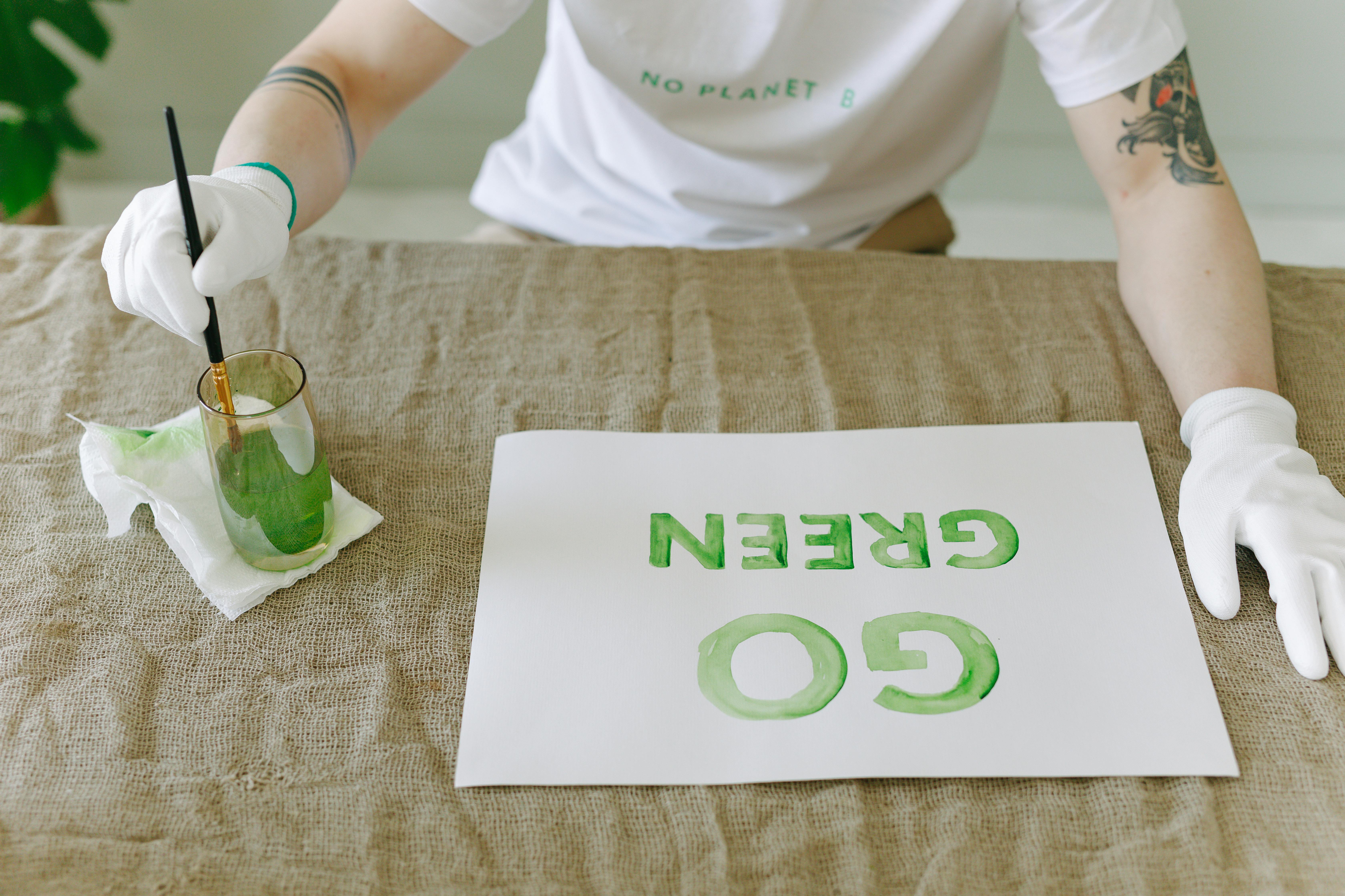 Person Painting Go Green on a Poster