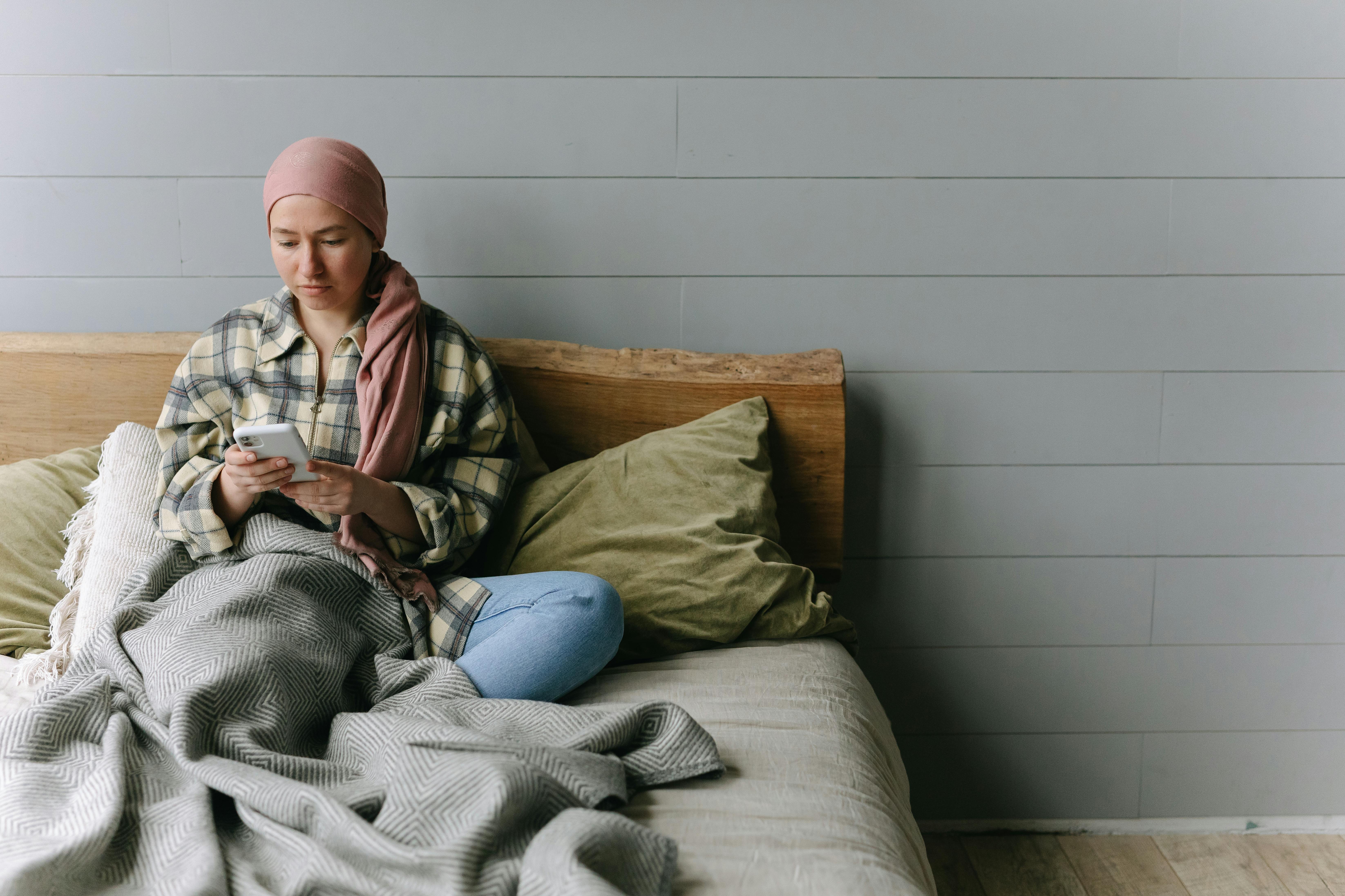 Woman using a Smartphone while Sitting on the Bed