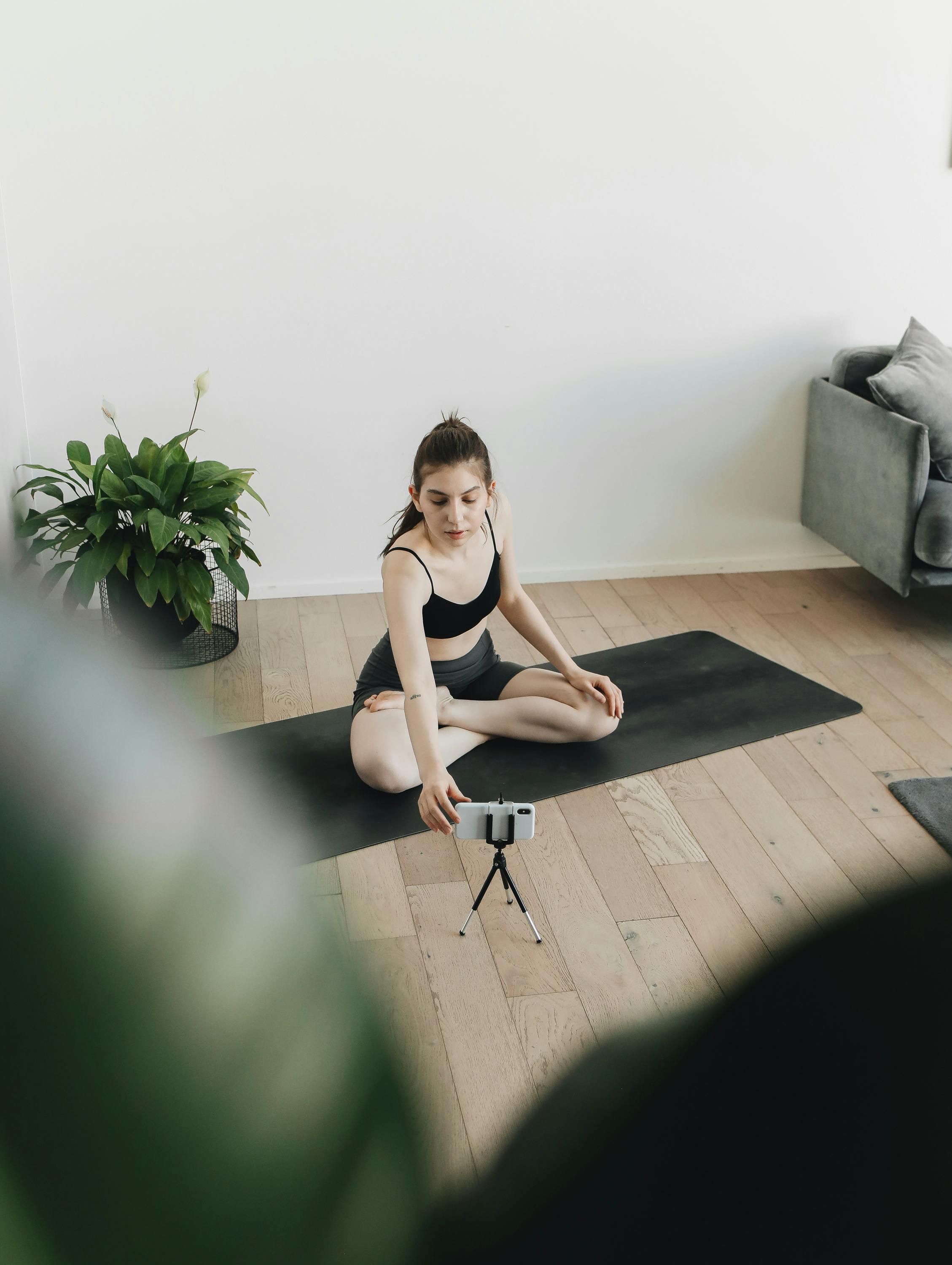 Woman in Black Tank Top Sitting on Black Yoga Mat