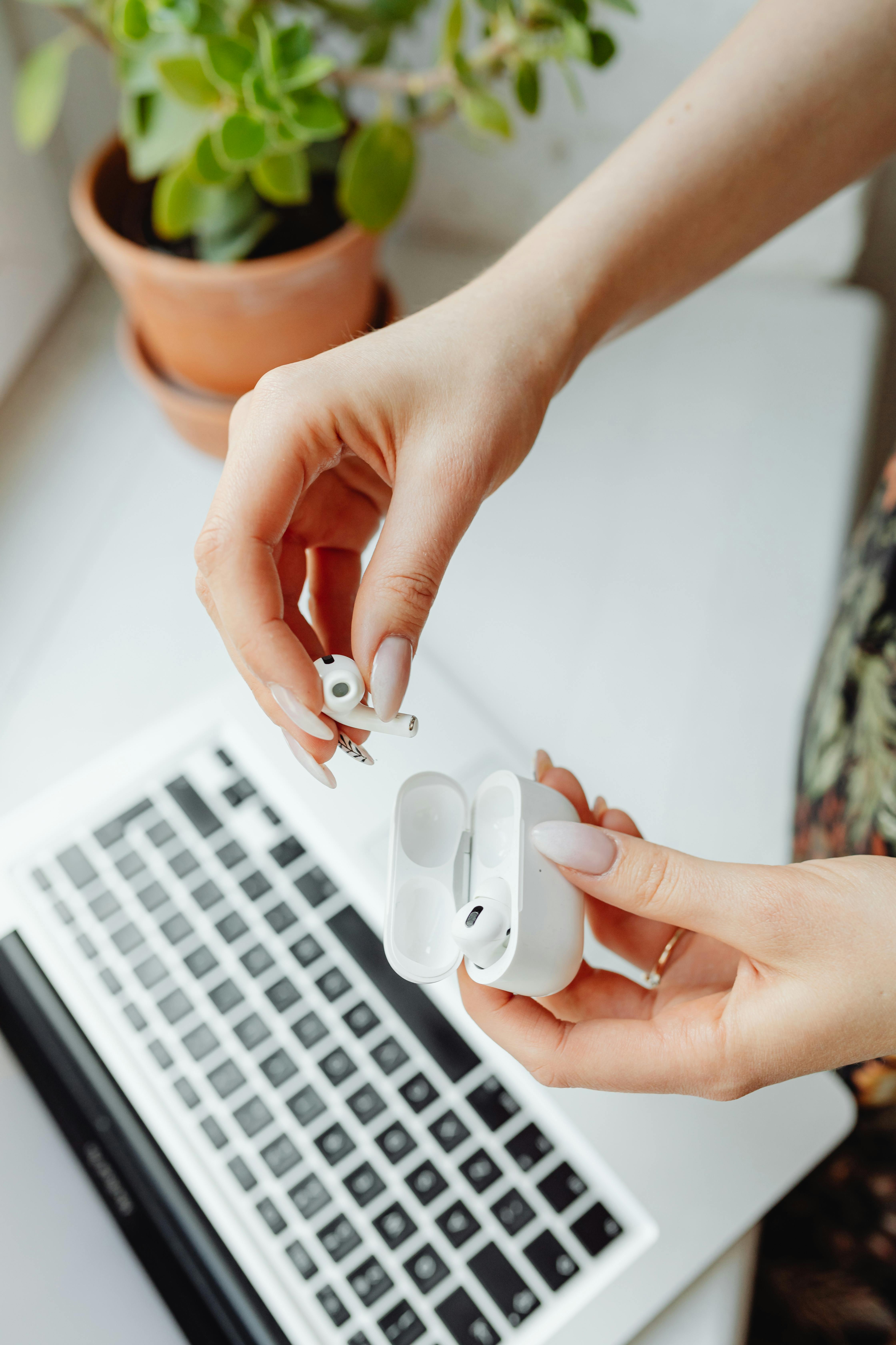 A Person Holding Airpods and Case