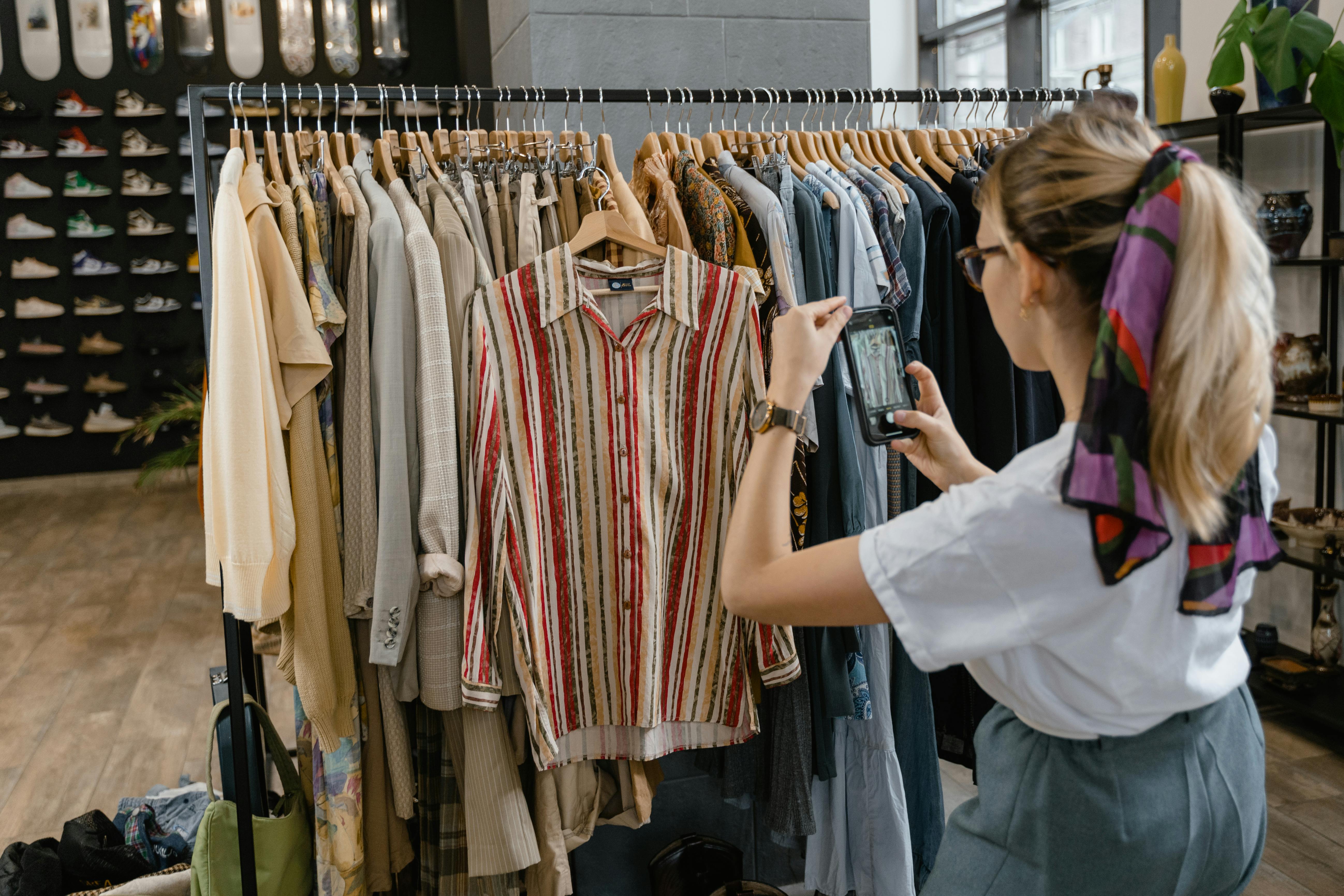 Woman in White Shirt Taking Photos of the Clothes on the Clothesline