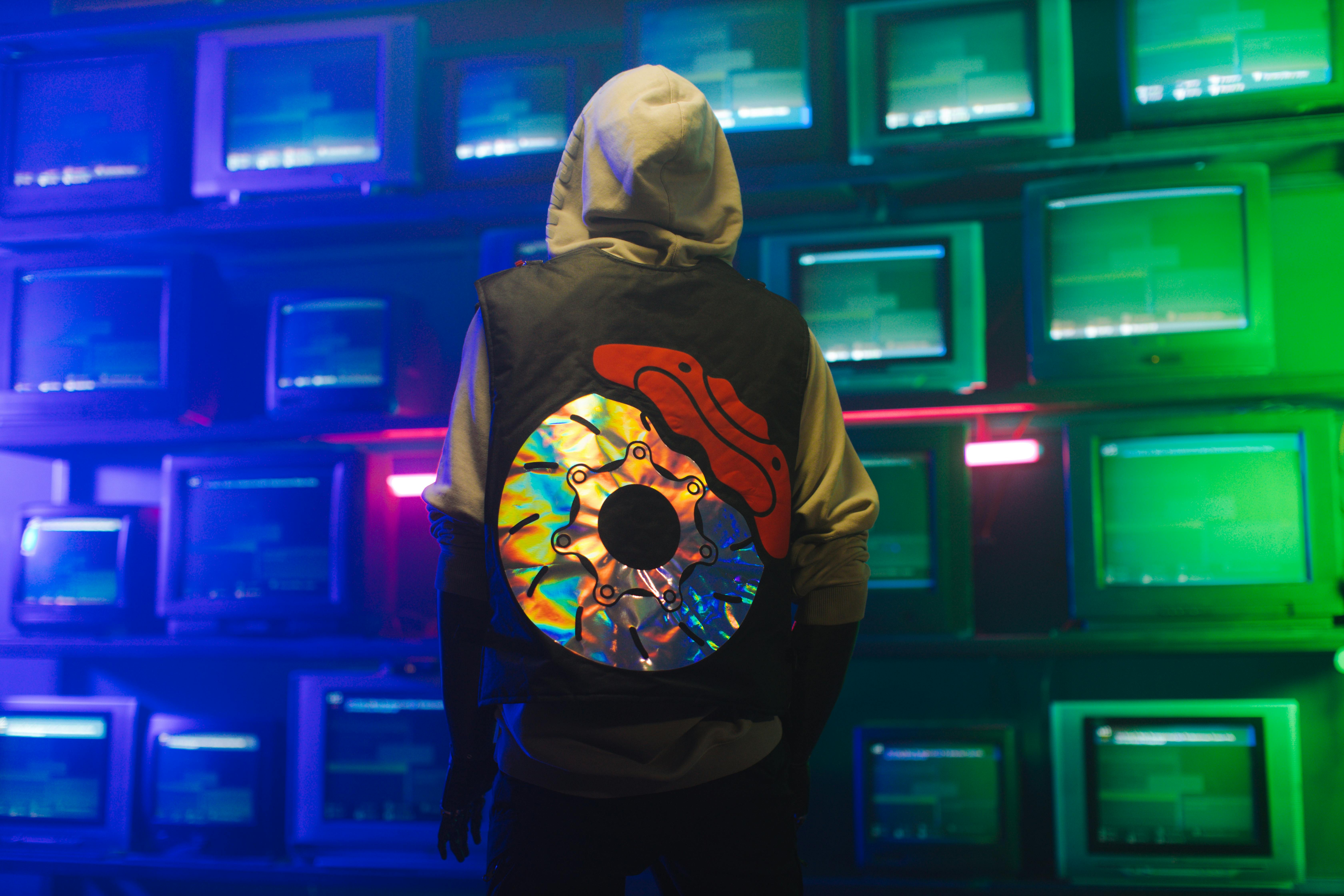 A person surrounded by vintage televisions, representing the retro futurism aesthetic