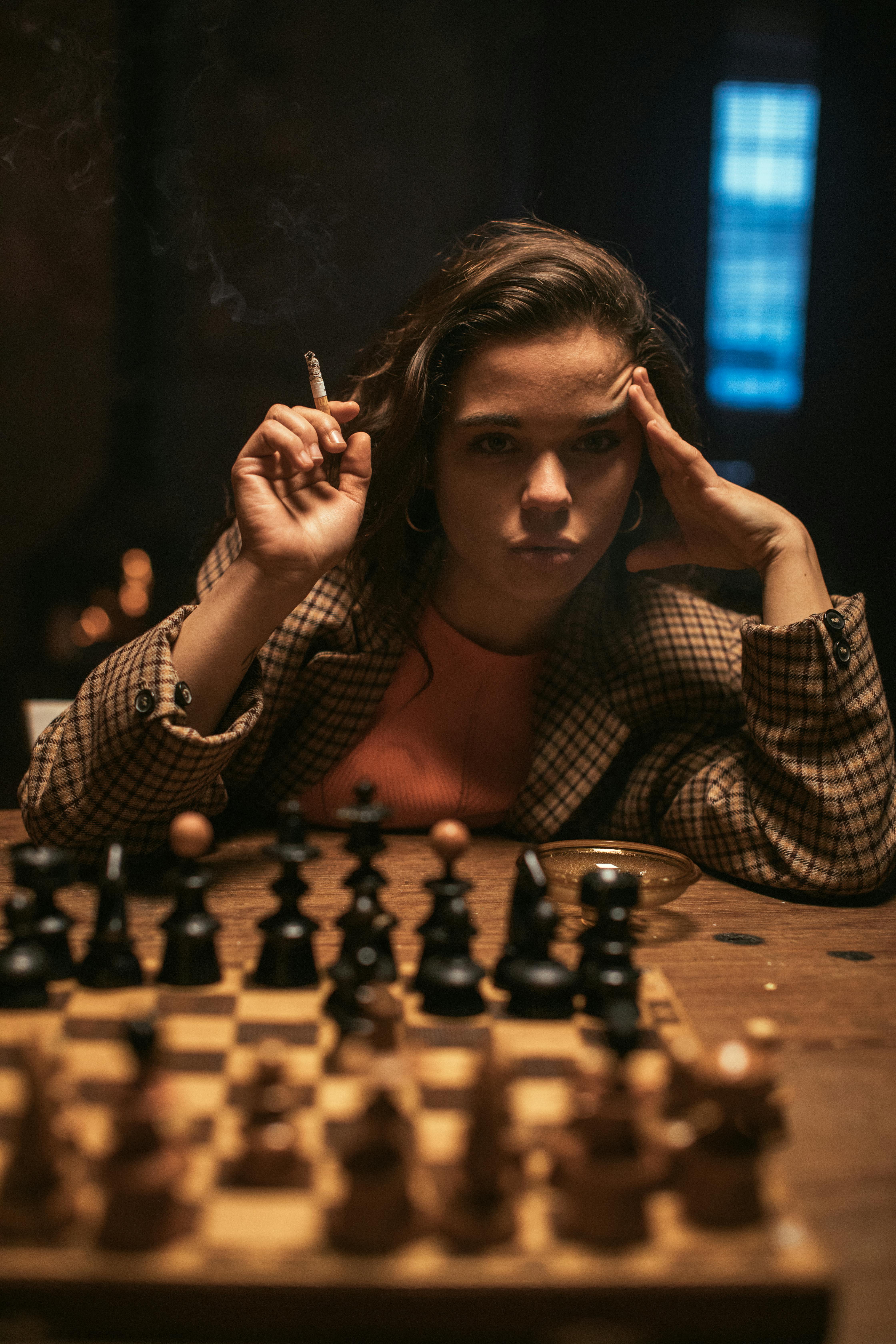 Woman Thinking while Smoking on Table with Chess