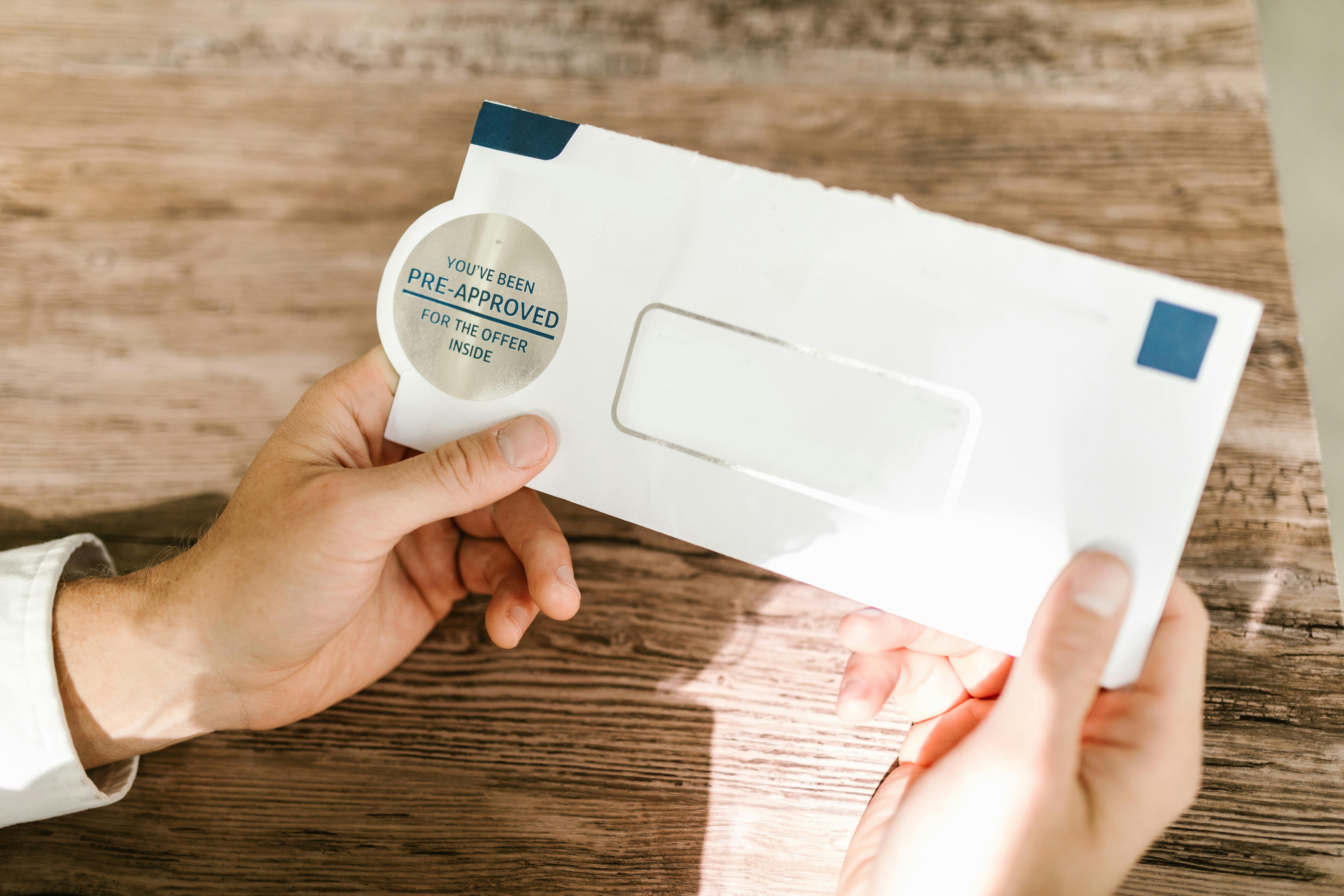 A Person Holding White and Blue Envelope