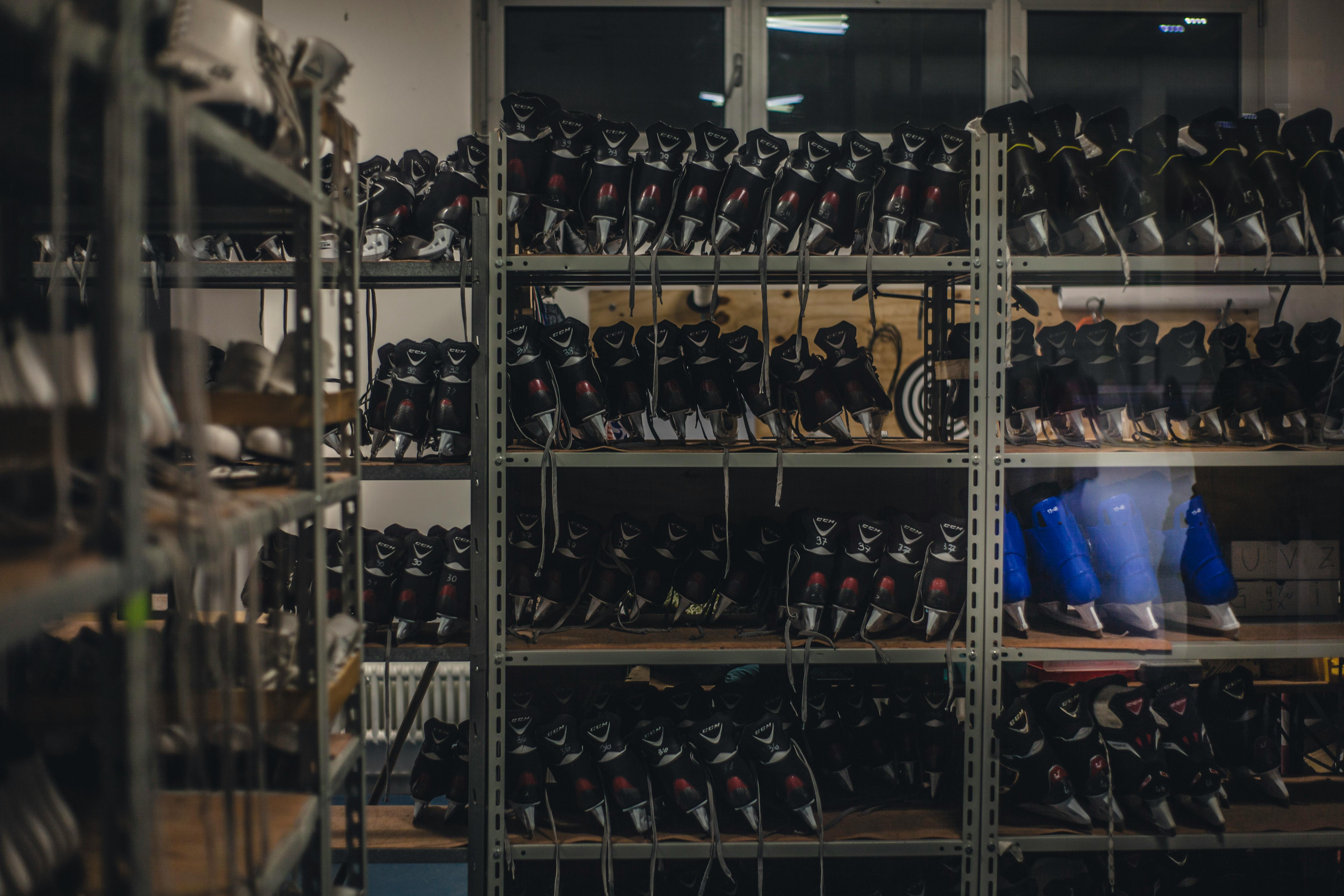 Black and Blue Ice Skates on Gray Metal Shelf