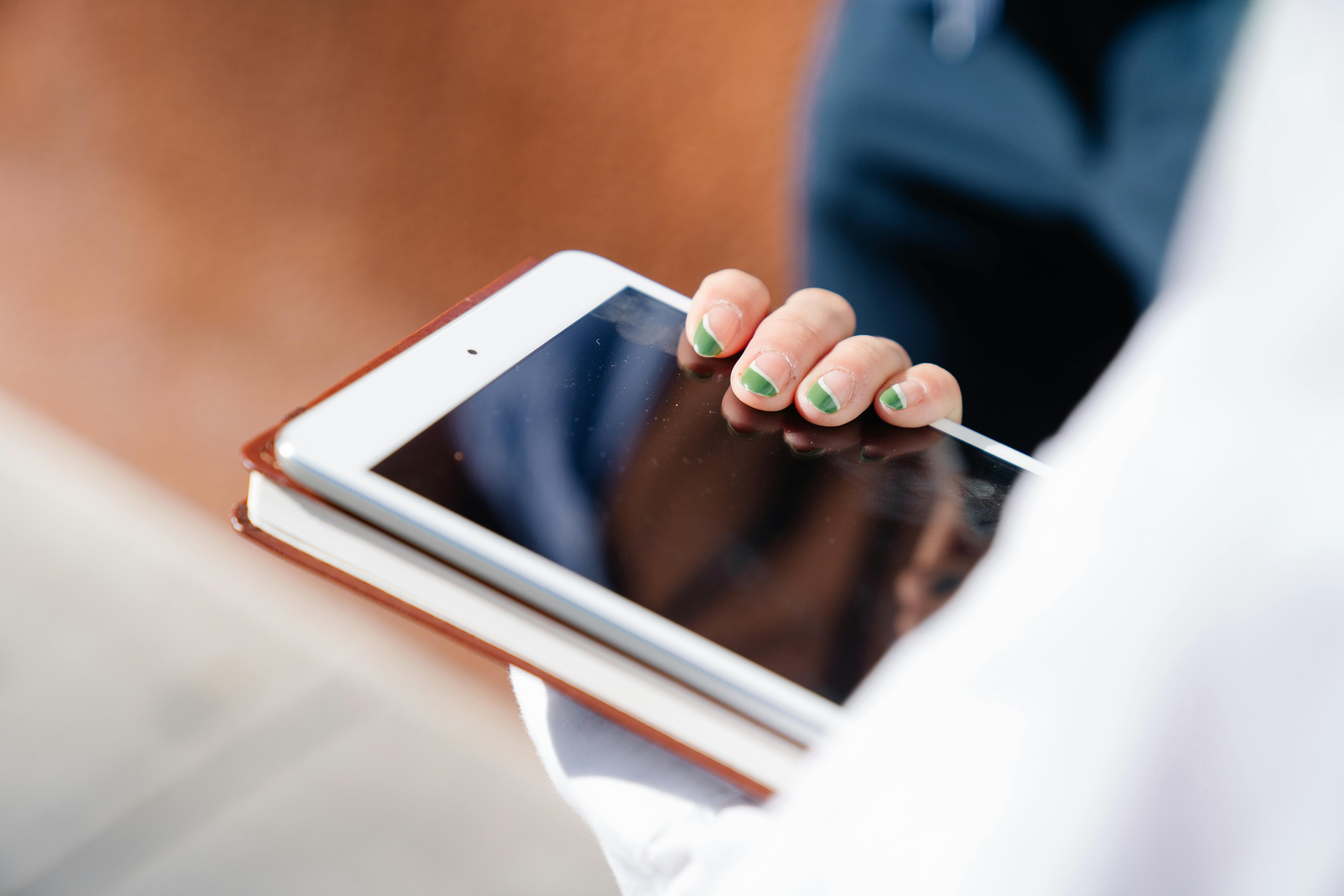 A Person Holding a Tablet and a Notebook