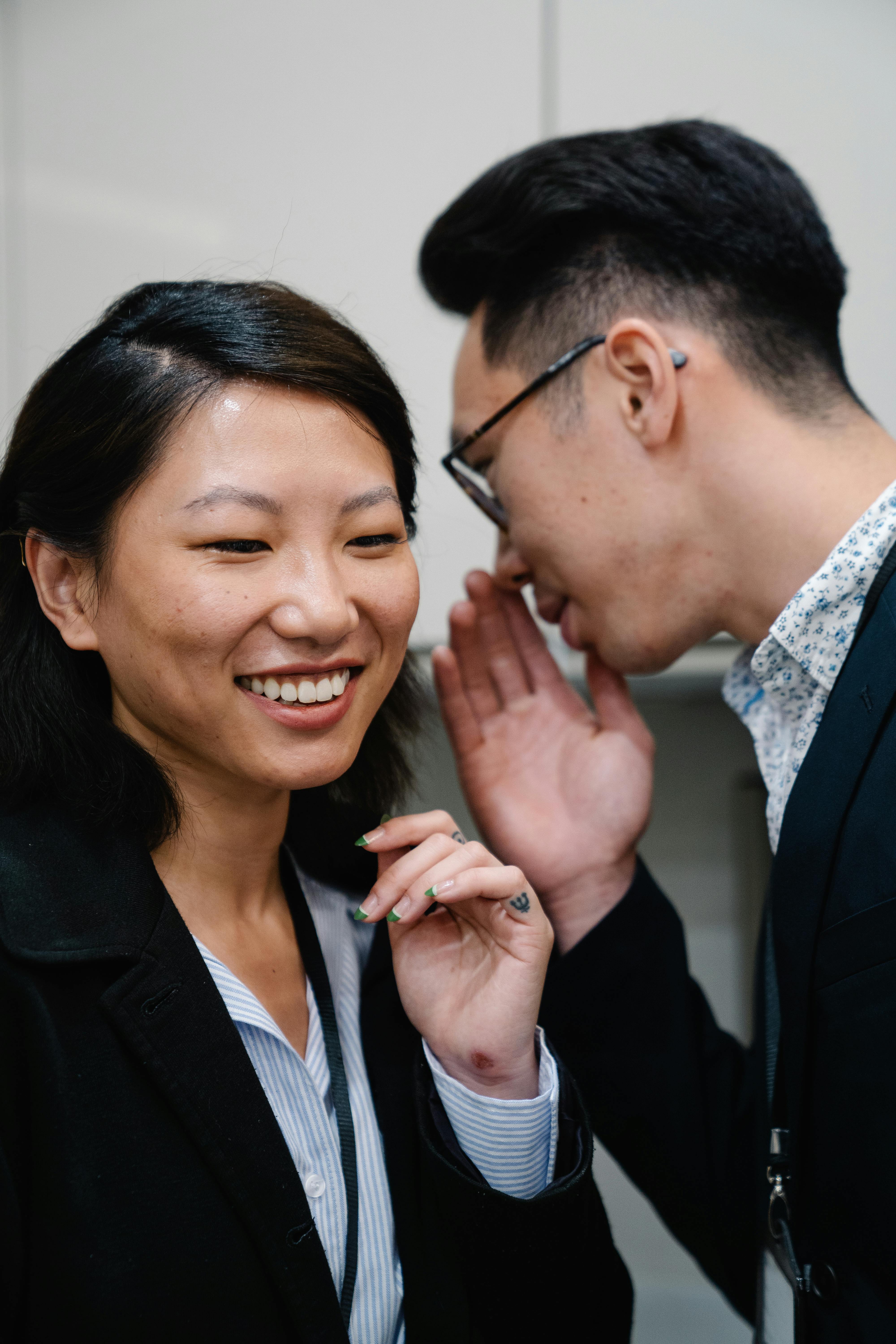 Photo of a Man Telling a Secret to a Woman