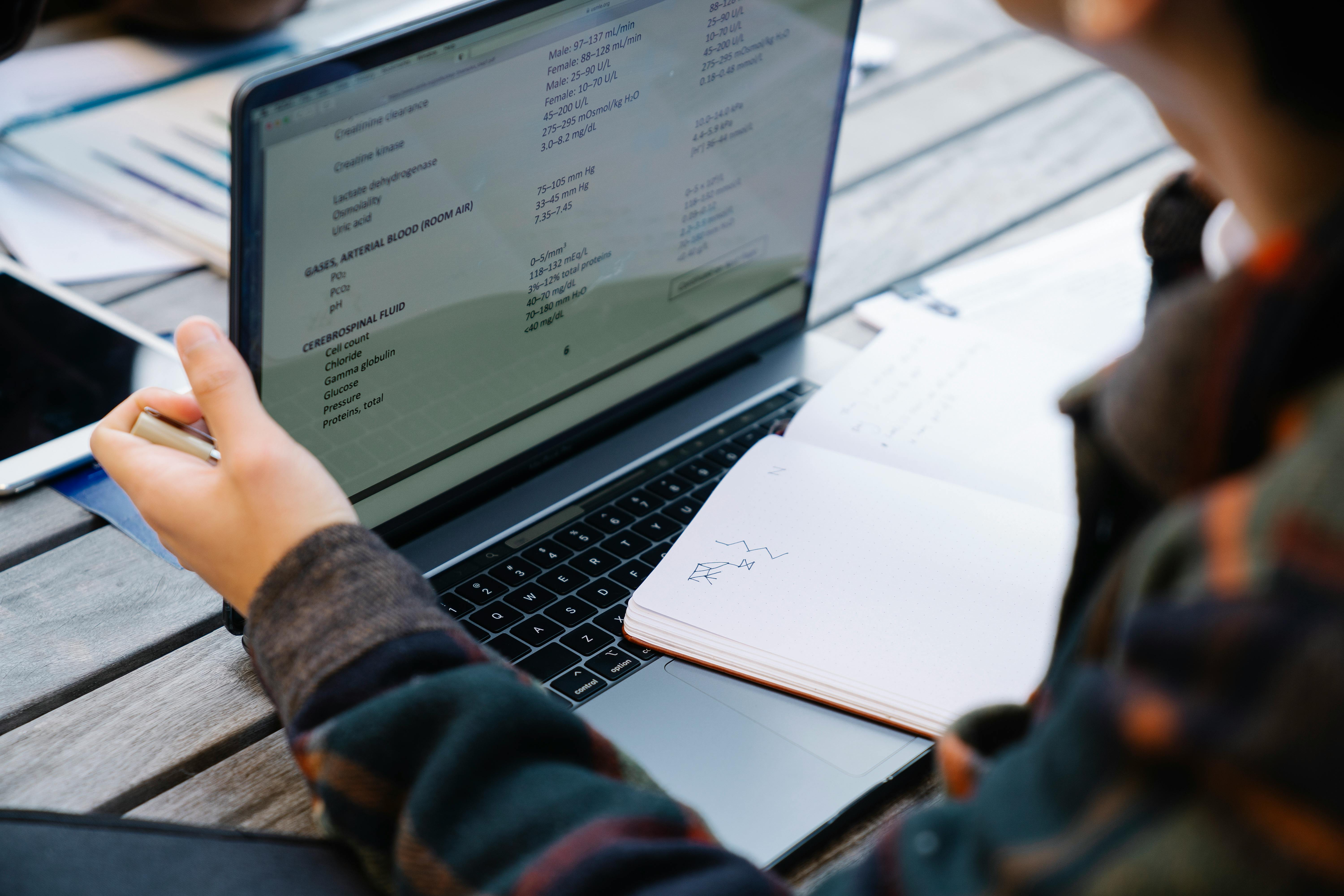 Person holding a laptop, symbolizing remote learning.