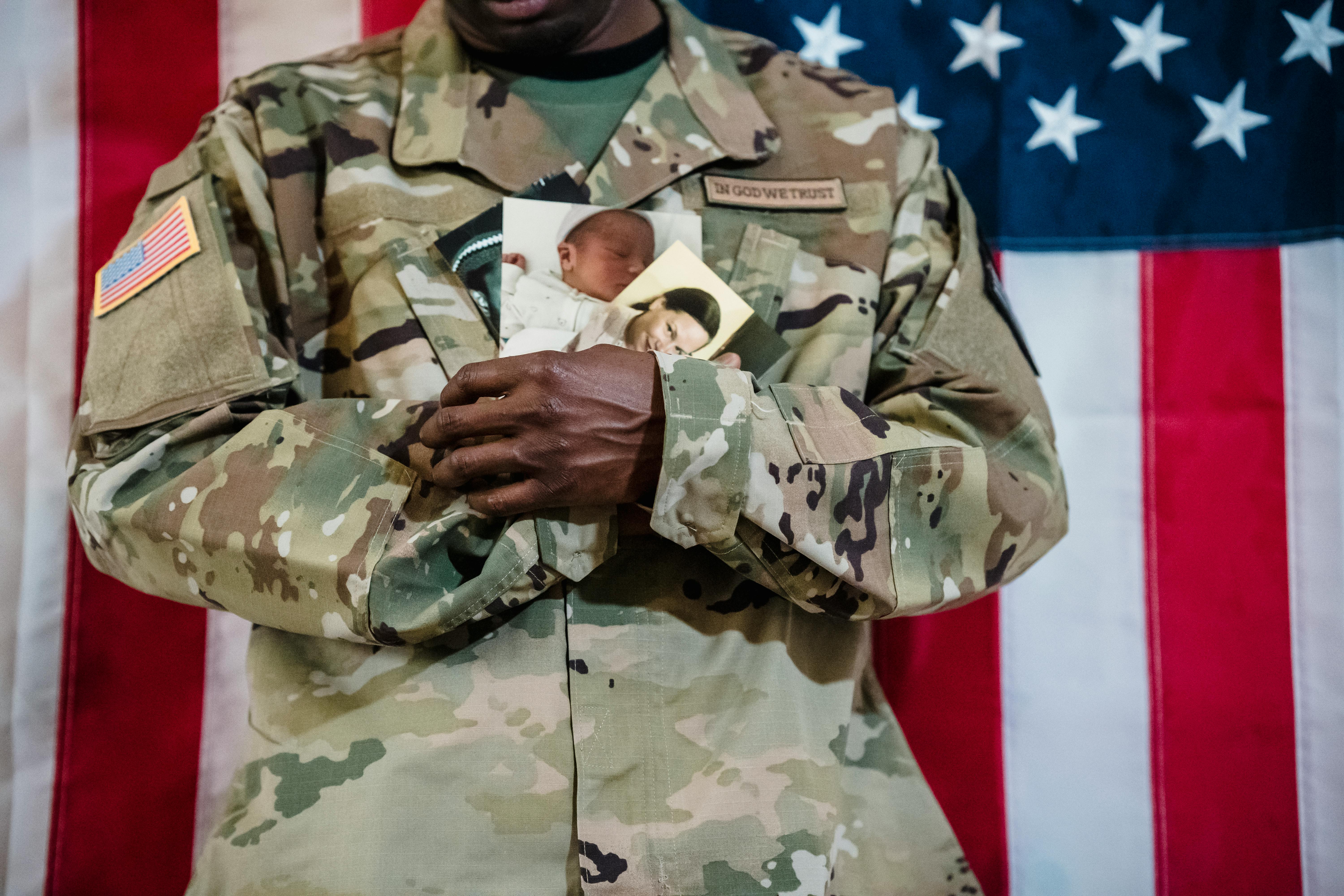 Soldier in Uniform Holding Family Photos