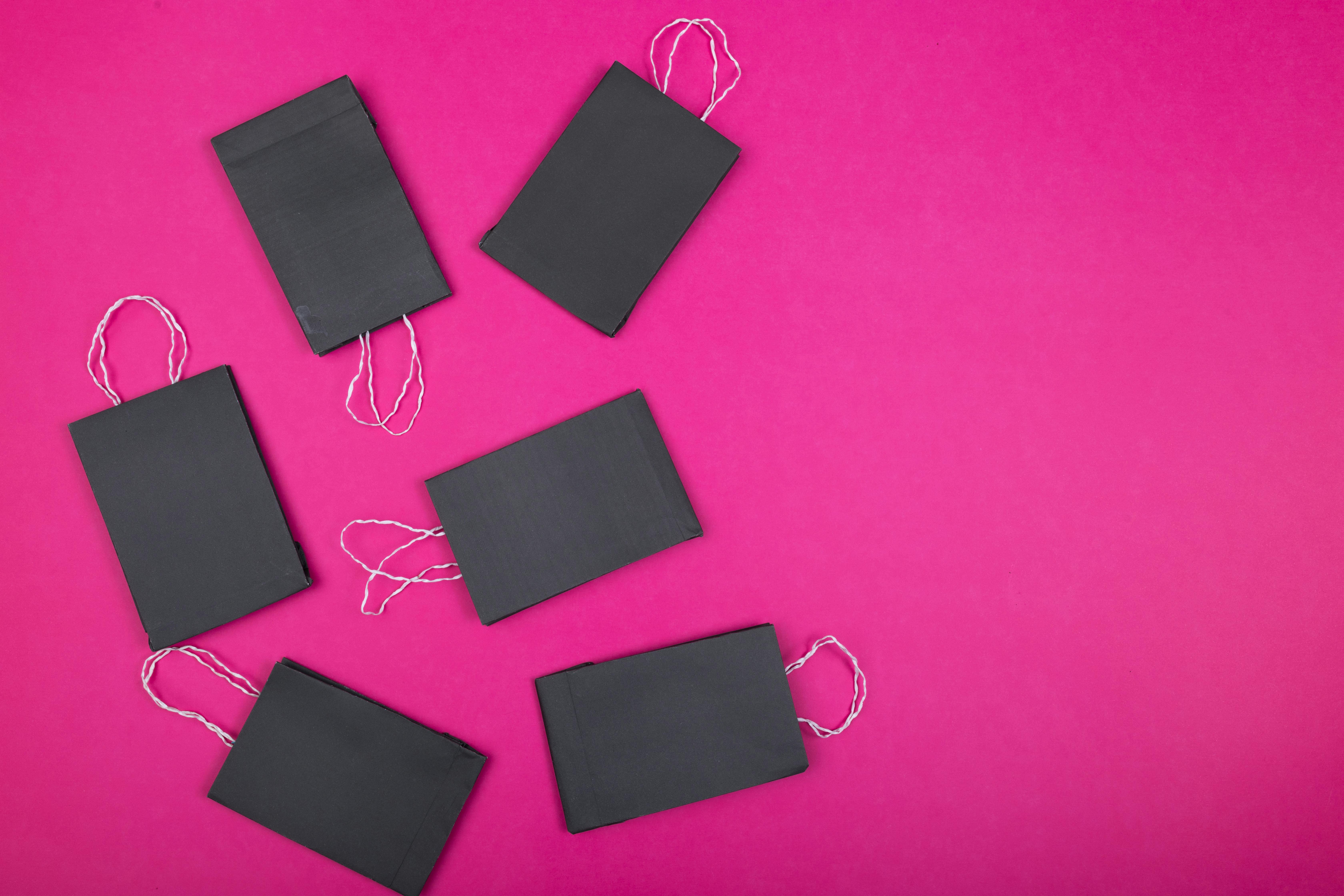 Black Paper Bags over a Pink Surface