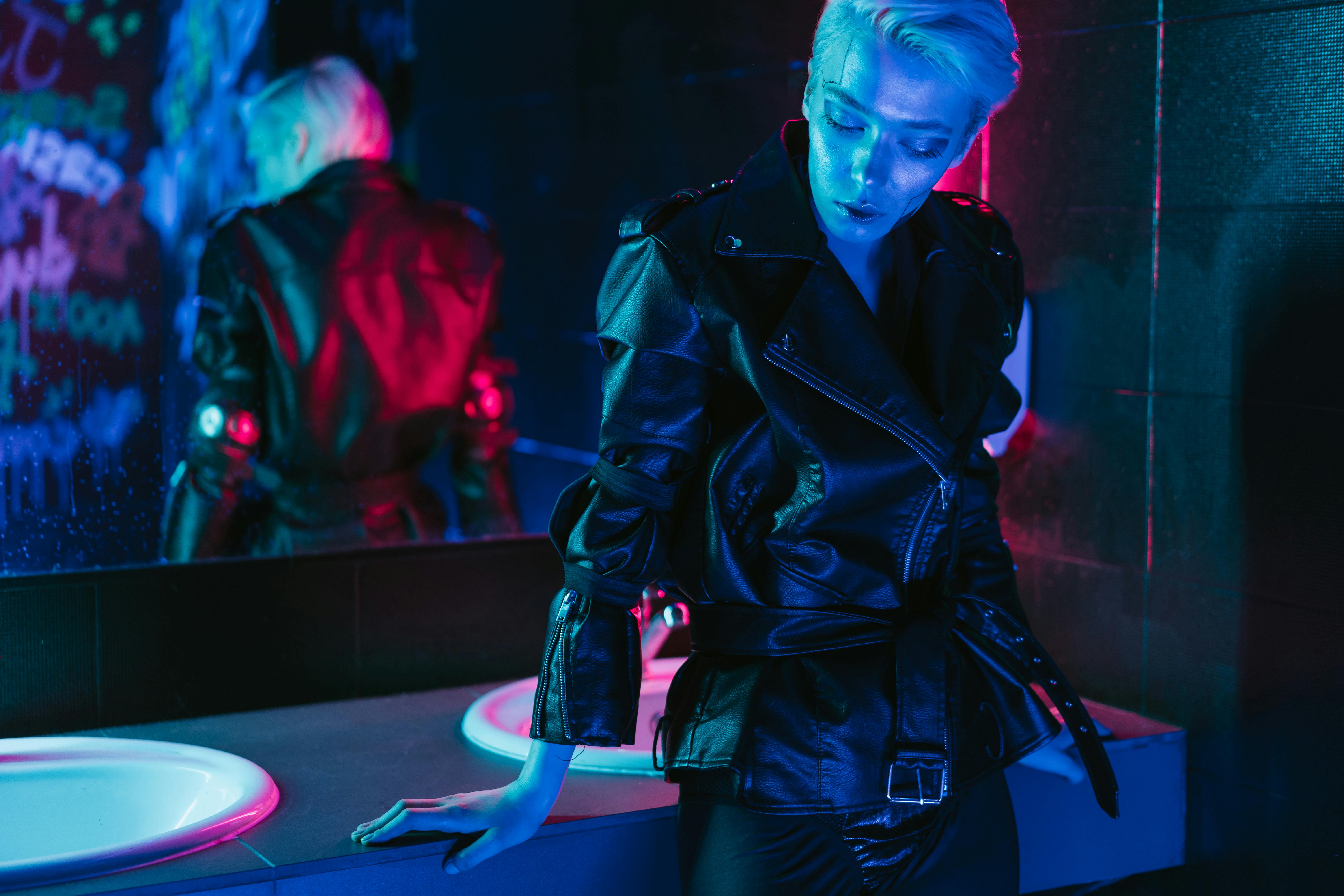 A Person in Black Jacket Standing Beside Sink