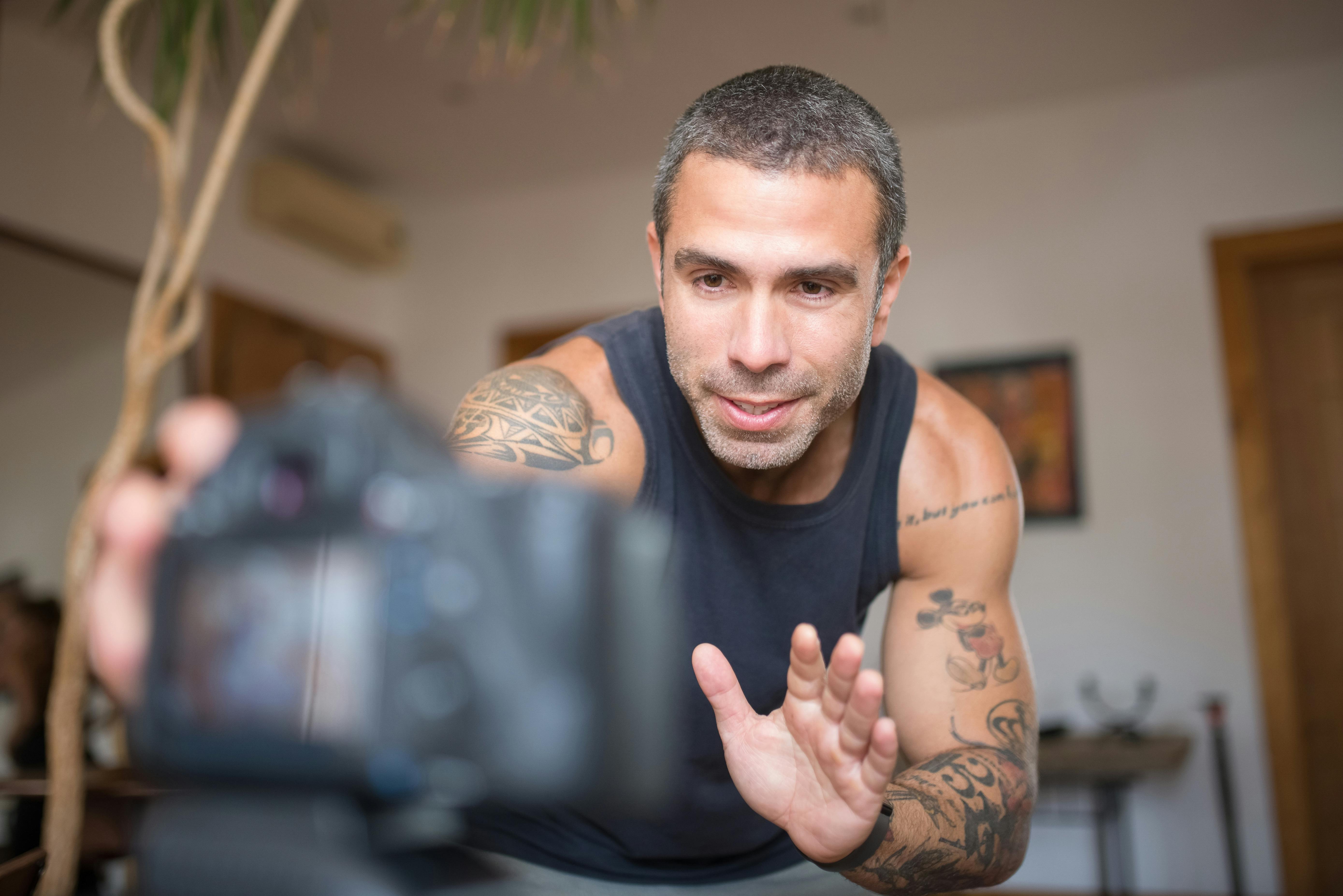 A Low Angle Shot of a Tattooed Man in Tank Top