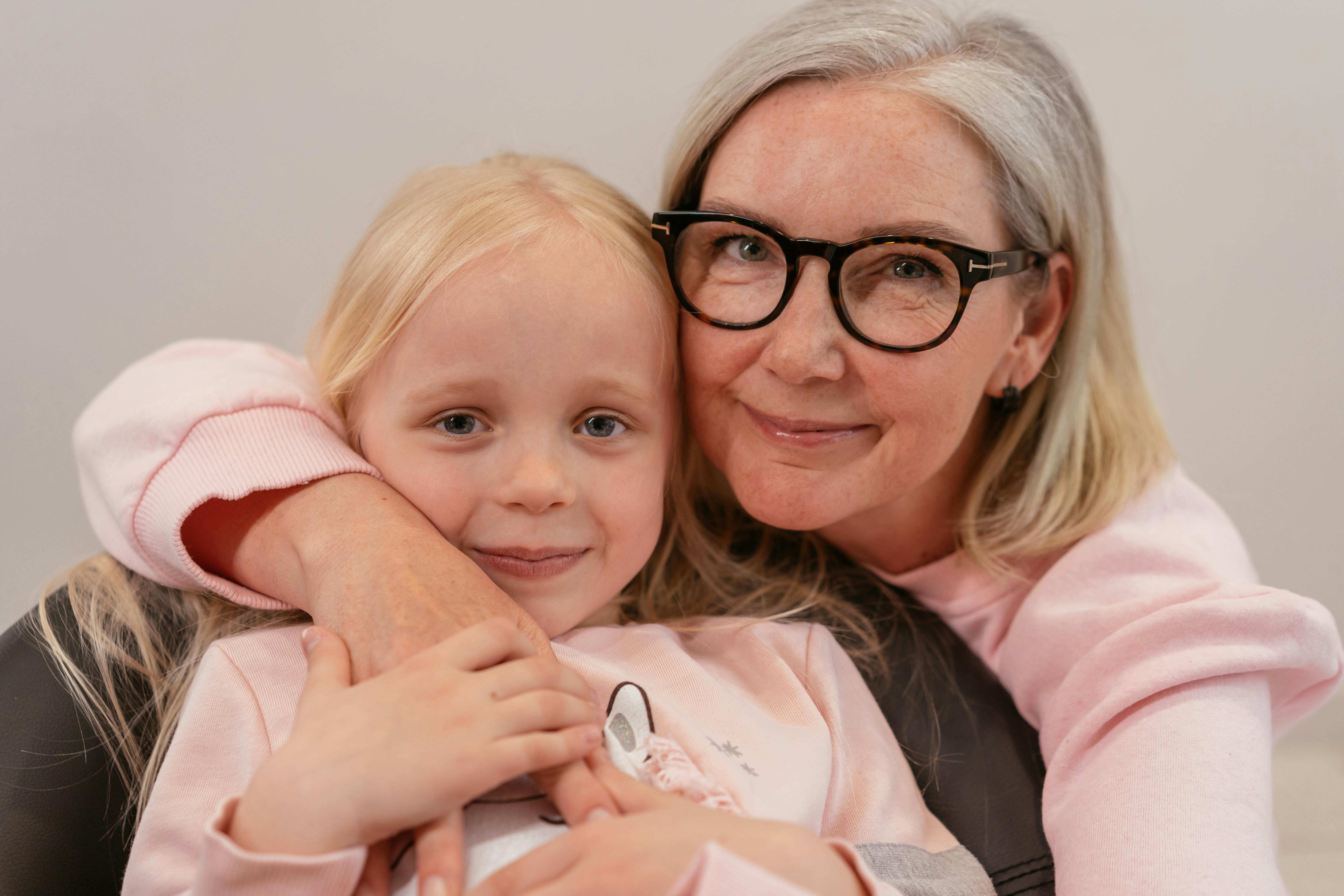 An Elderly Woman Embracing Her Grandchild