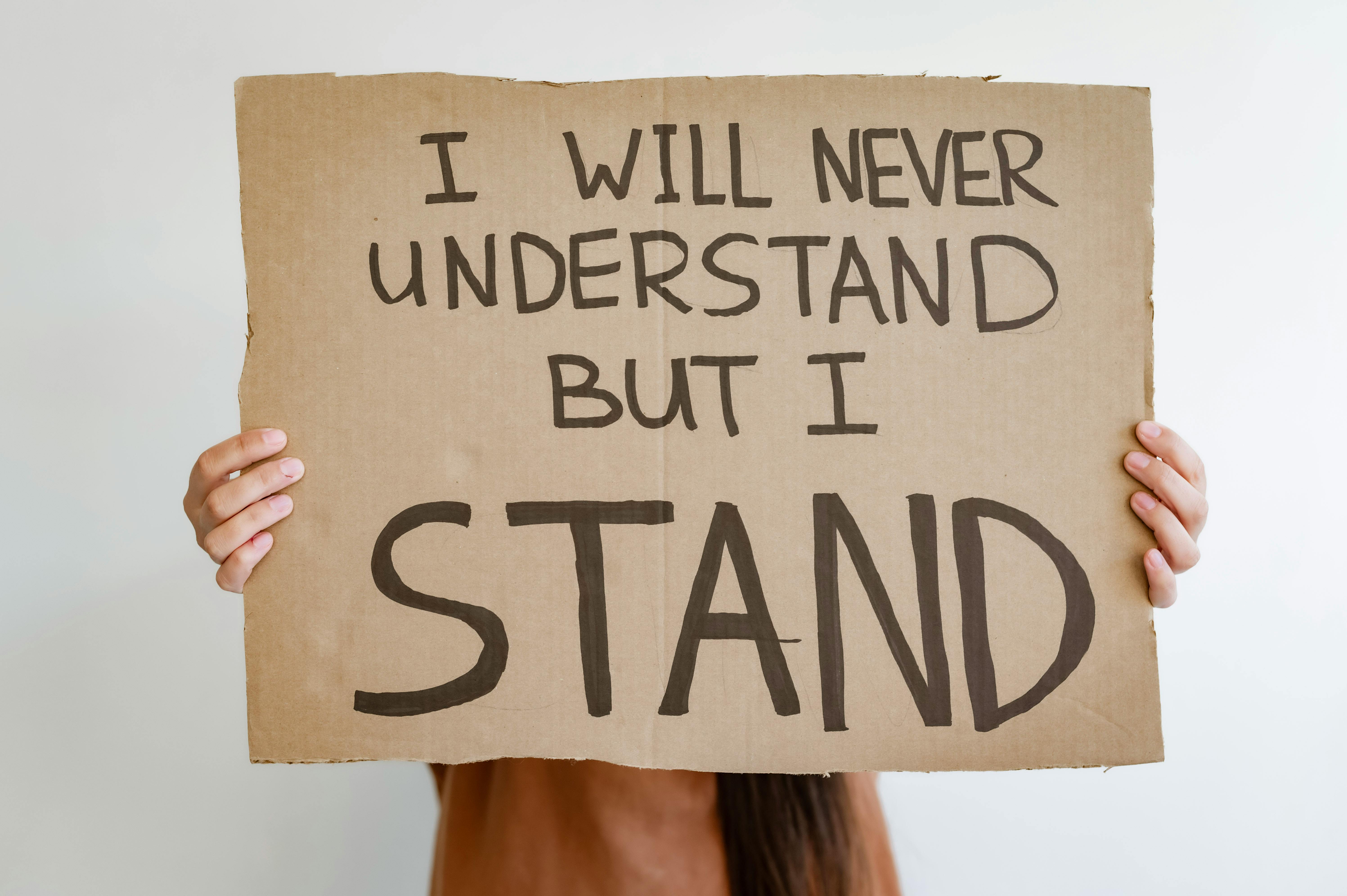 Person Holding Brown Cardboard with Text