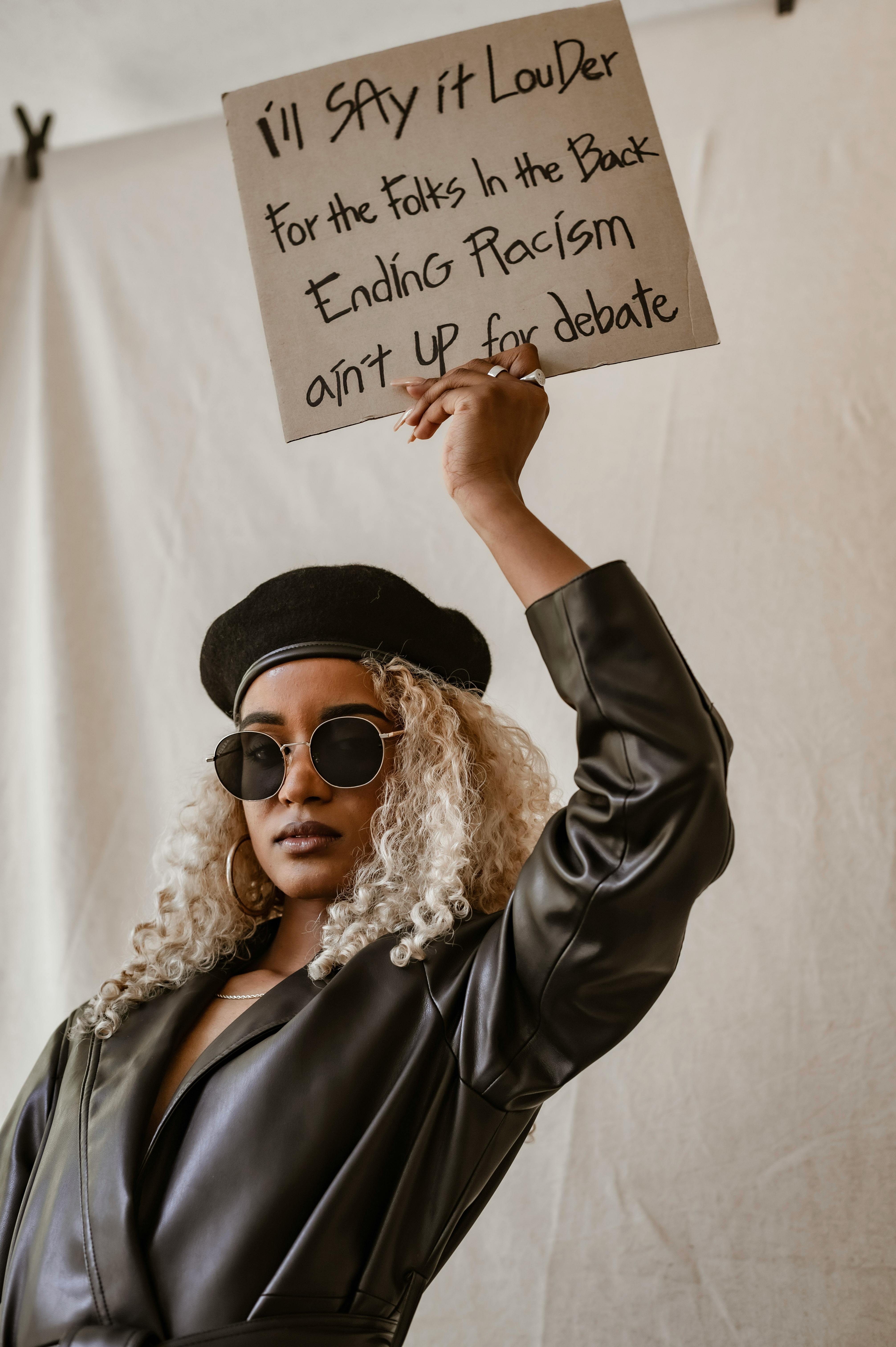 A Woman Raising Her Arms while Holding a Placard