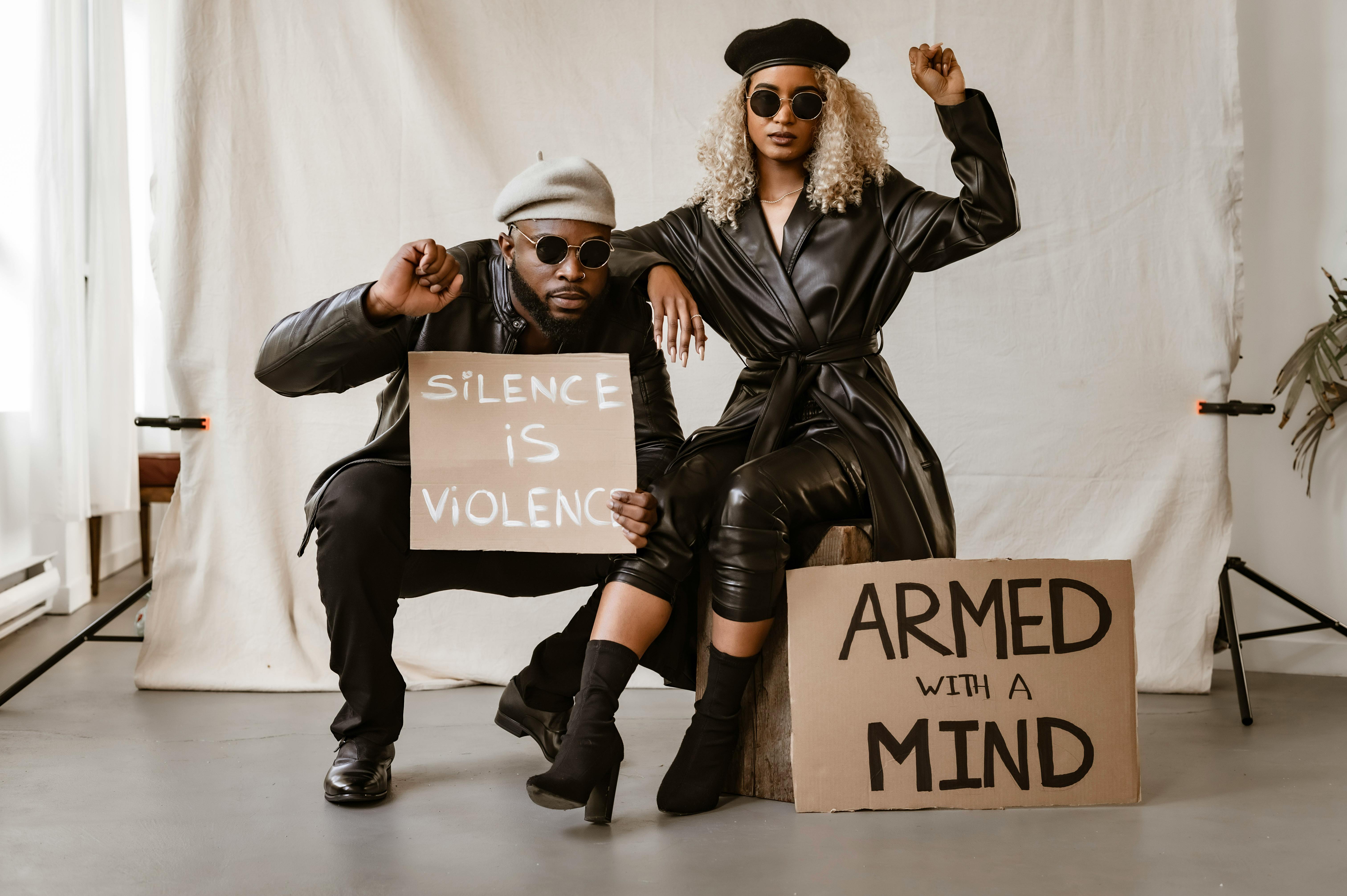 A Couple in Leather Wear Holding Posters