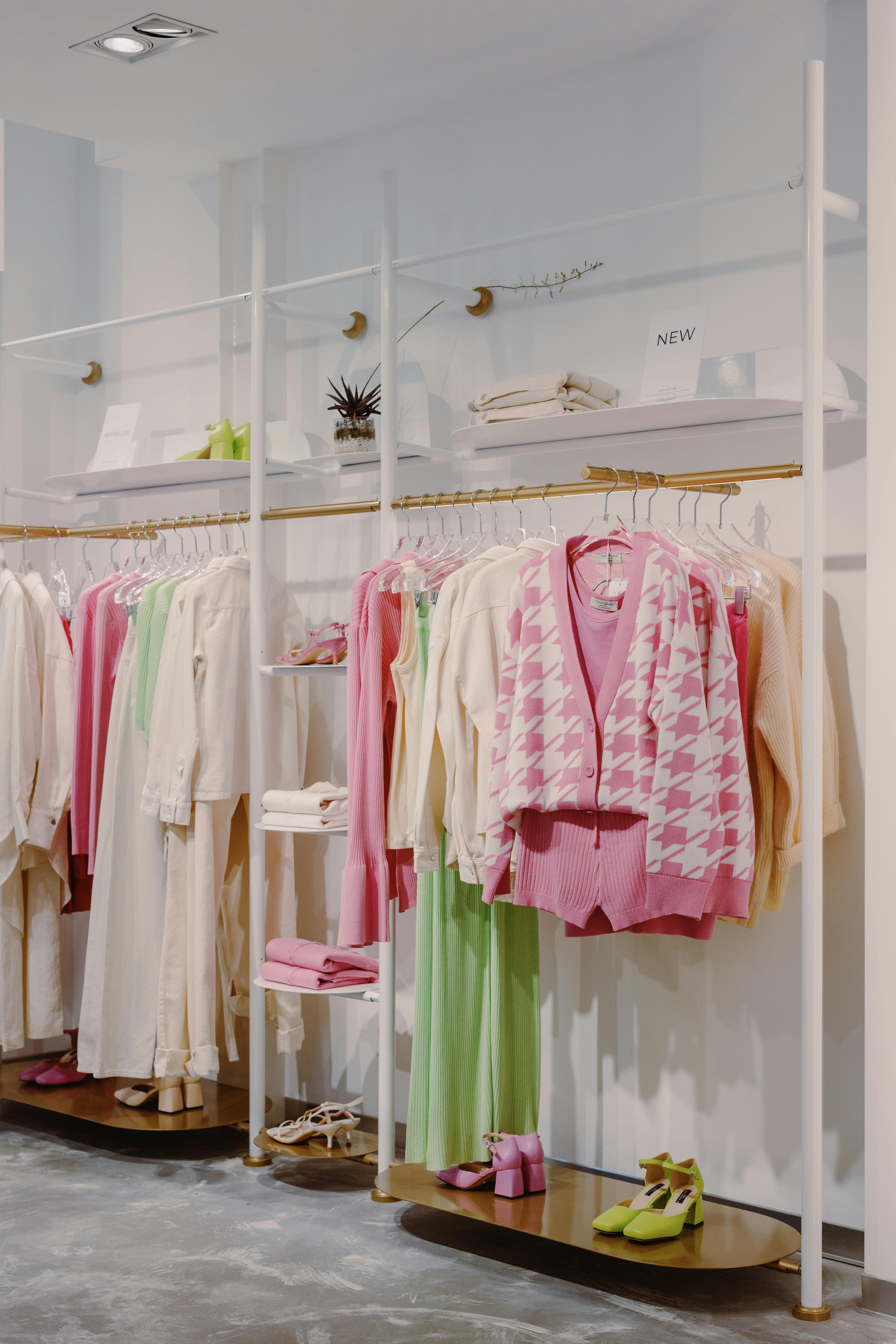 Pink and White Long Sleeve Shirt Hanging on Gold and White Clothing Rack