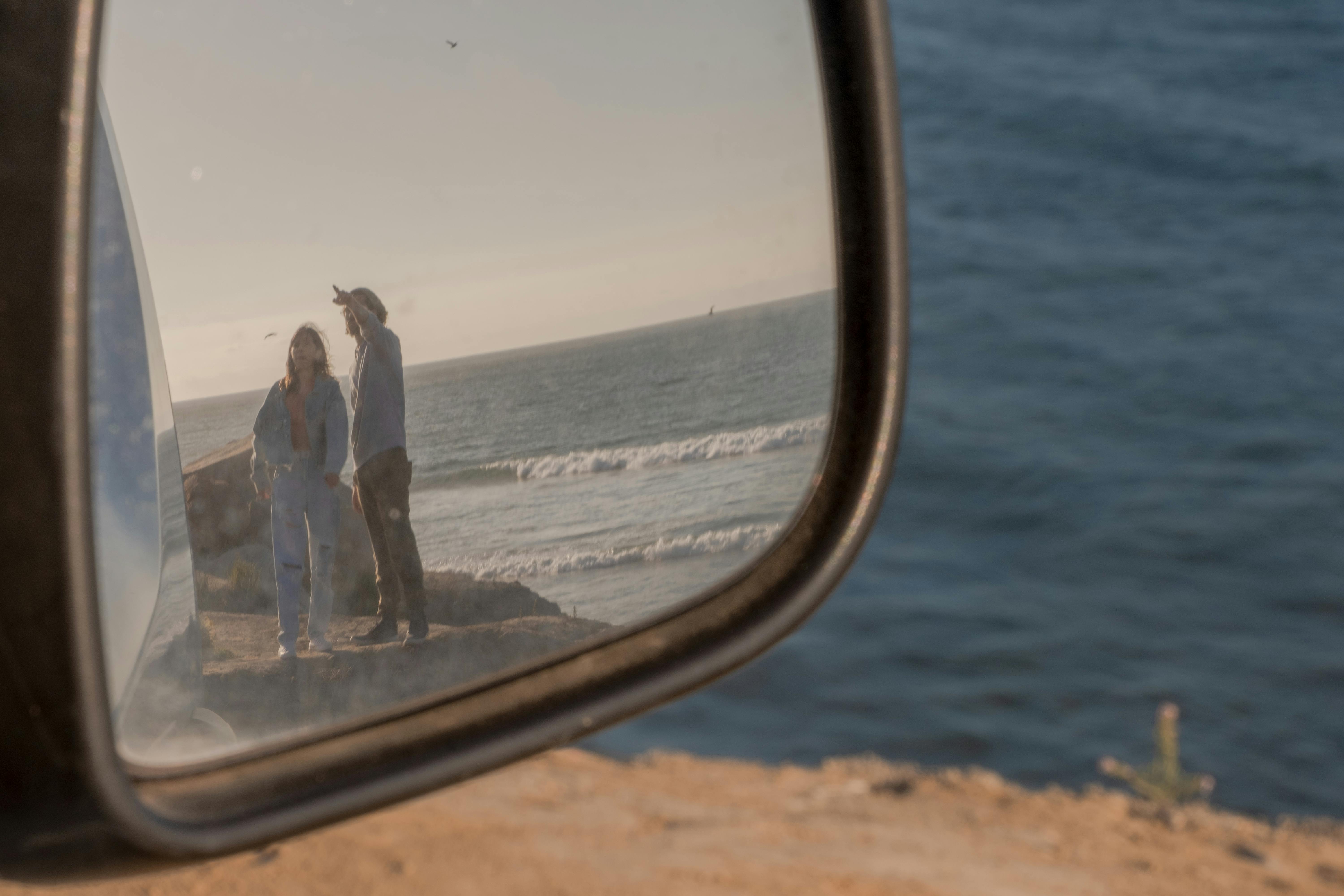 View of a Man and Woman Reflecting on the Side Mirror