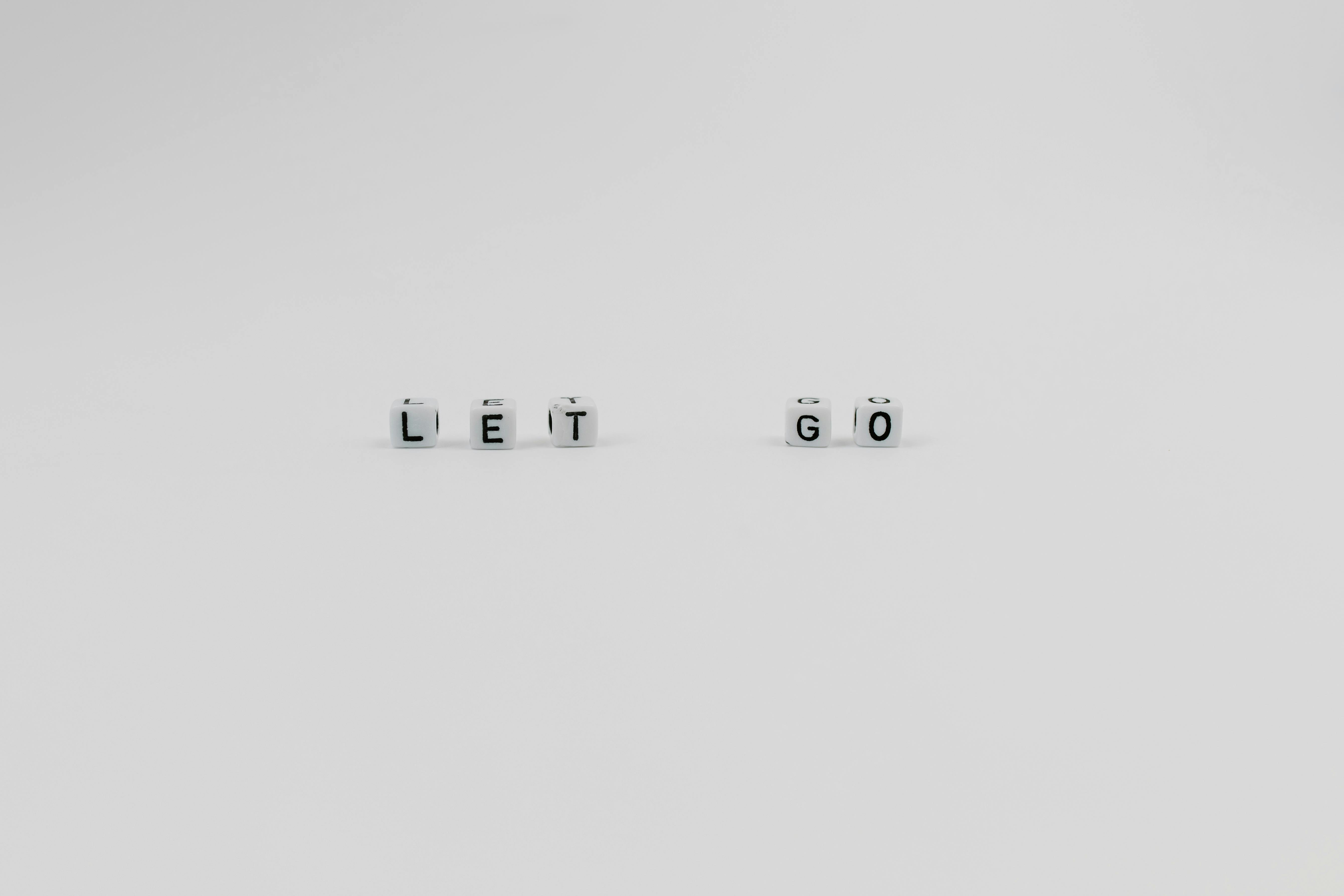 A Let Go Slogan Spelled with Letter Dice on White Background