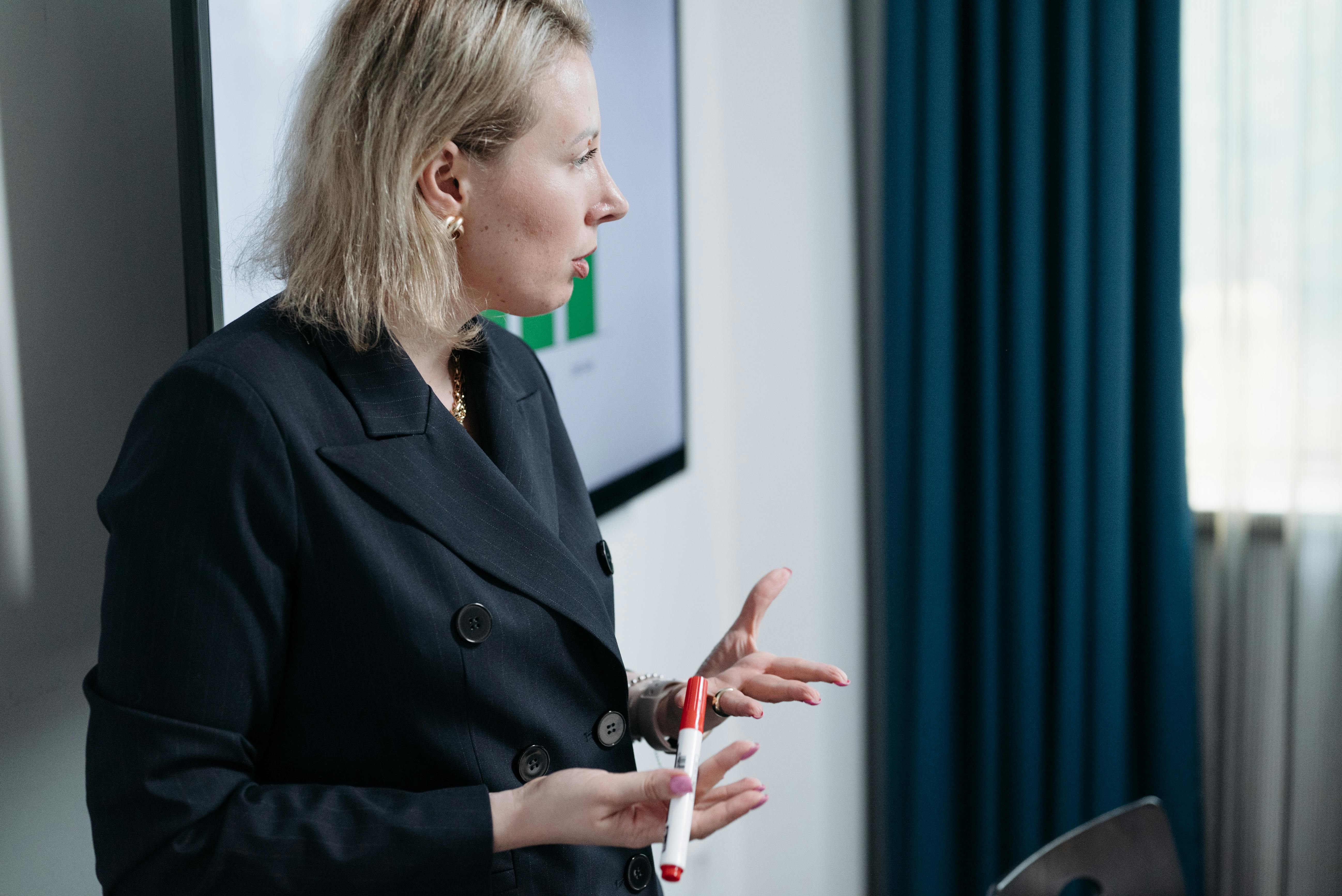 A Woman Holding a Pen while Discussing