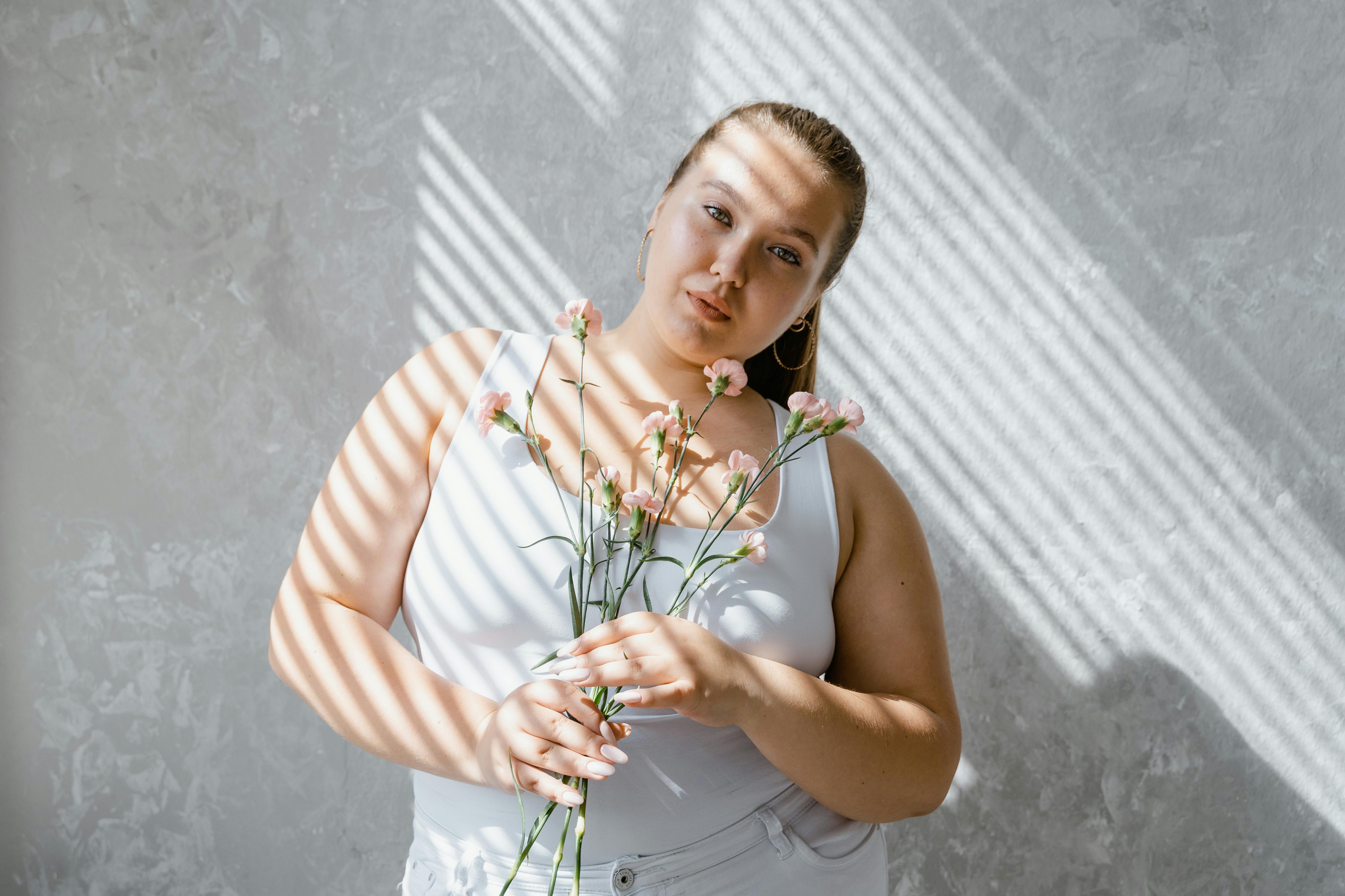 A Confident Plumpy Woman in Tank Top Holding Flowers