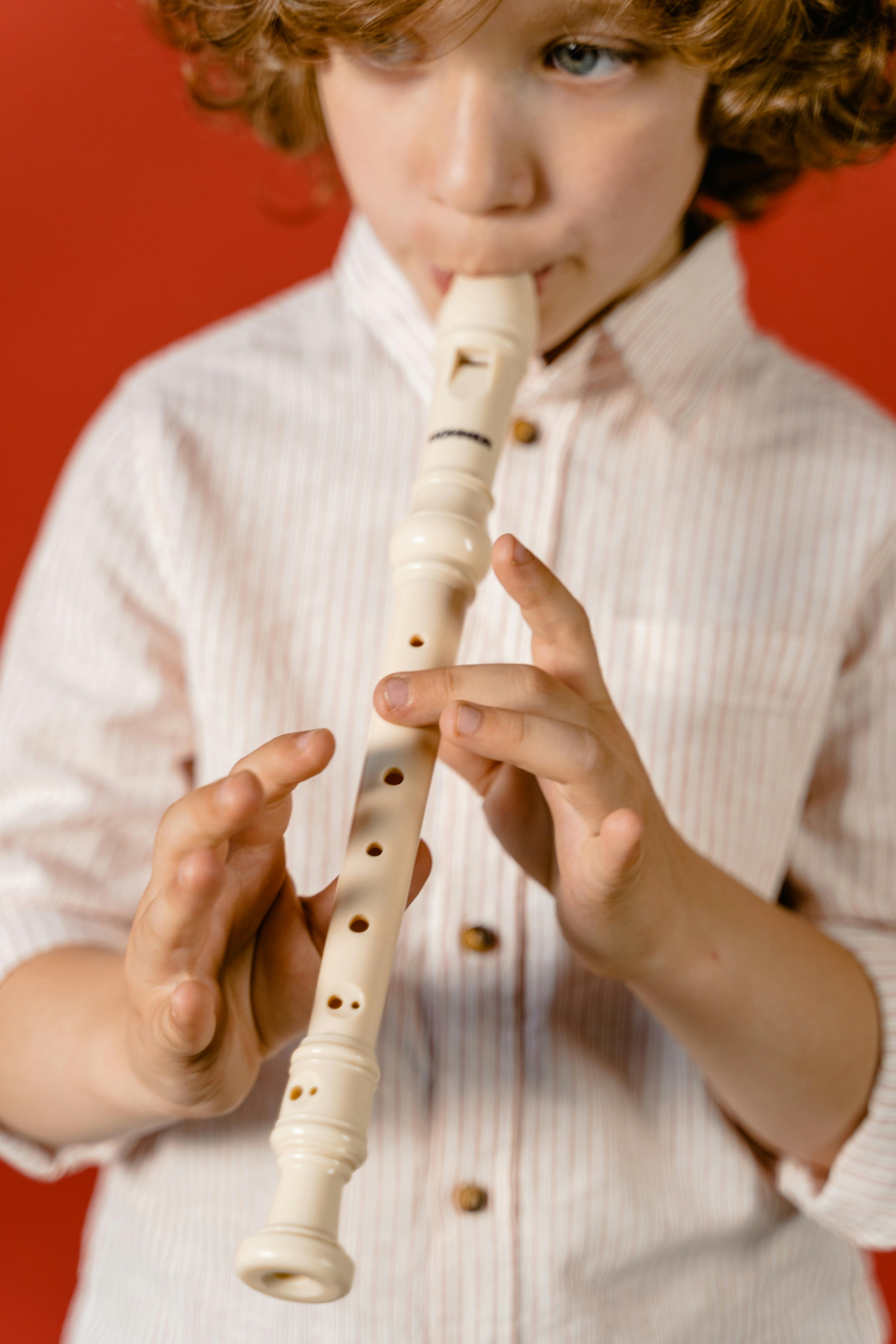 Close-Up Photo of a Boy Playing His Flute