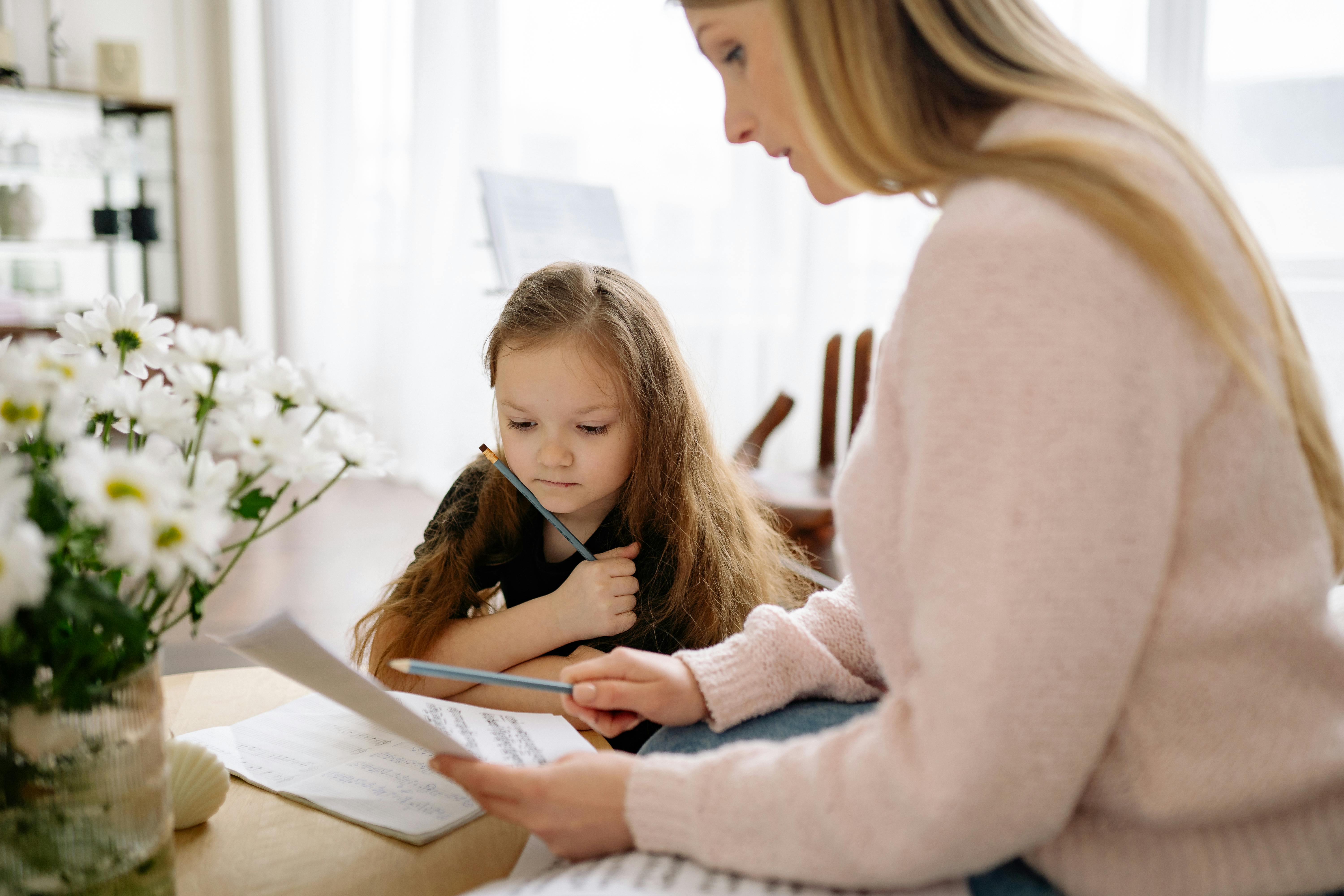 Woman in Pink Sweater Teaching a Girl