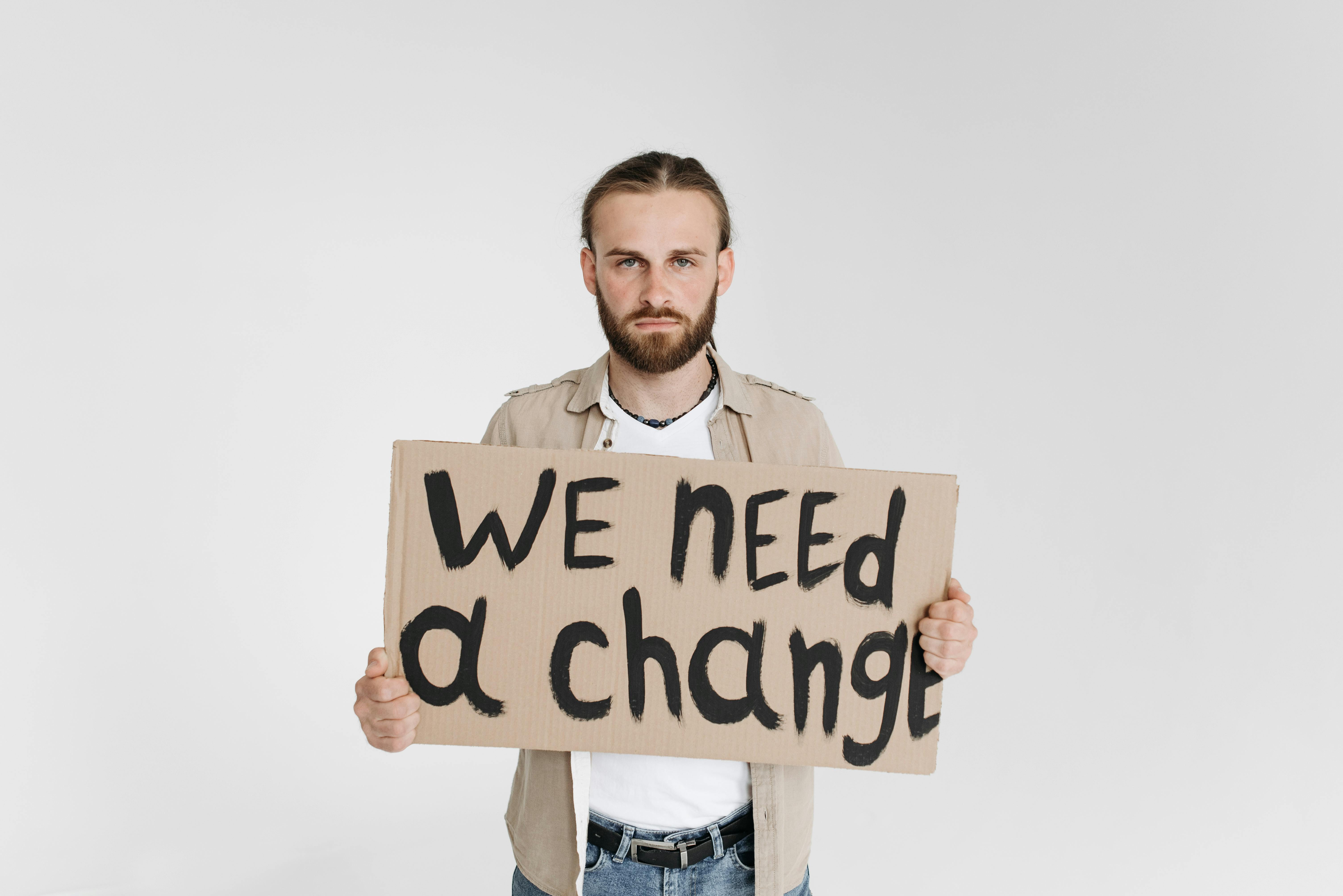 Man with a Protest Sign Saying We Need a Change