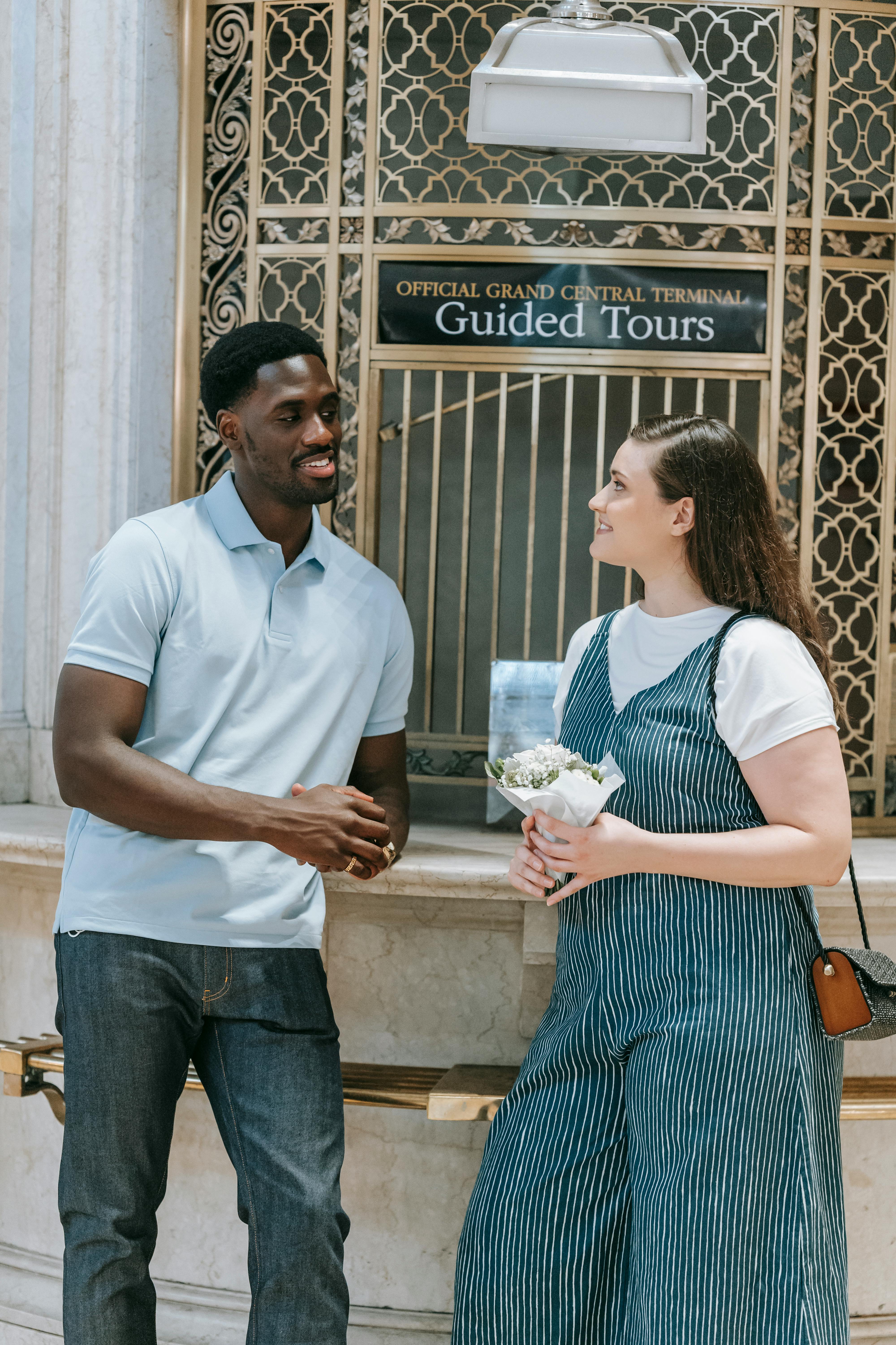 Woman Holding Flowers While Talking to a Man